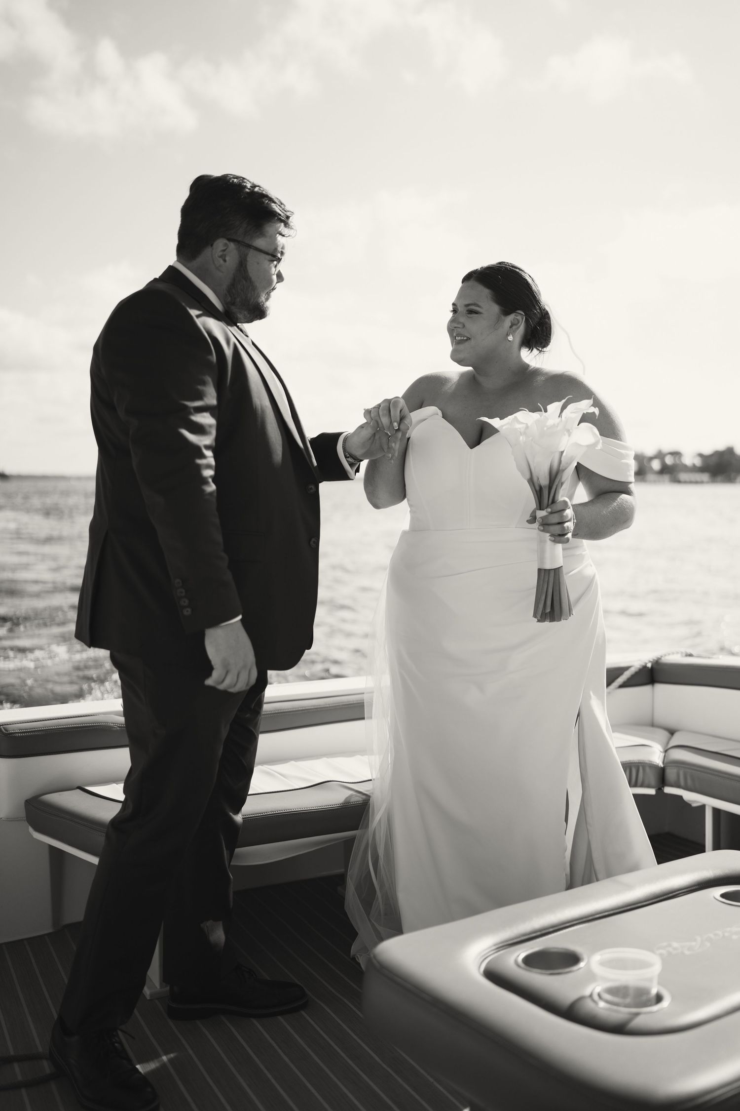 A couple shares a moment on a boat deck during their wedding day.