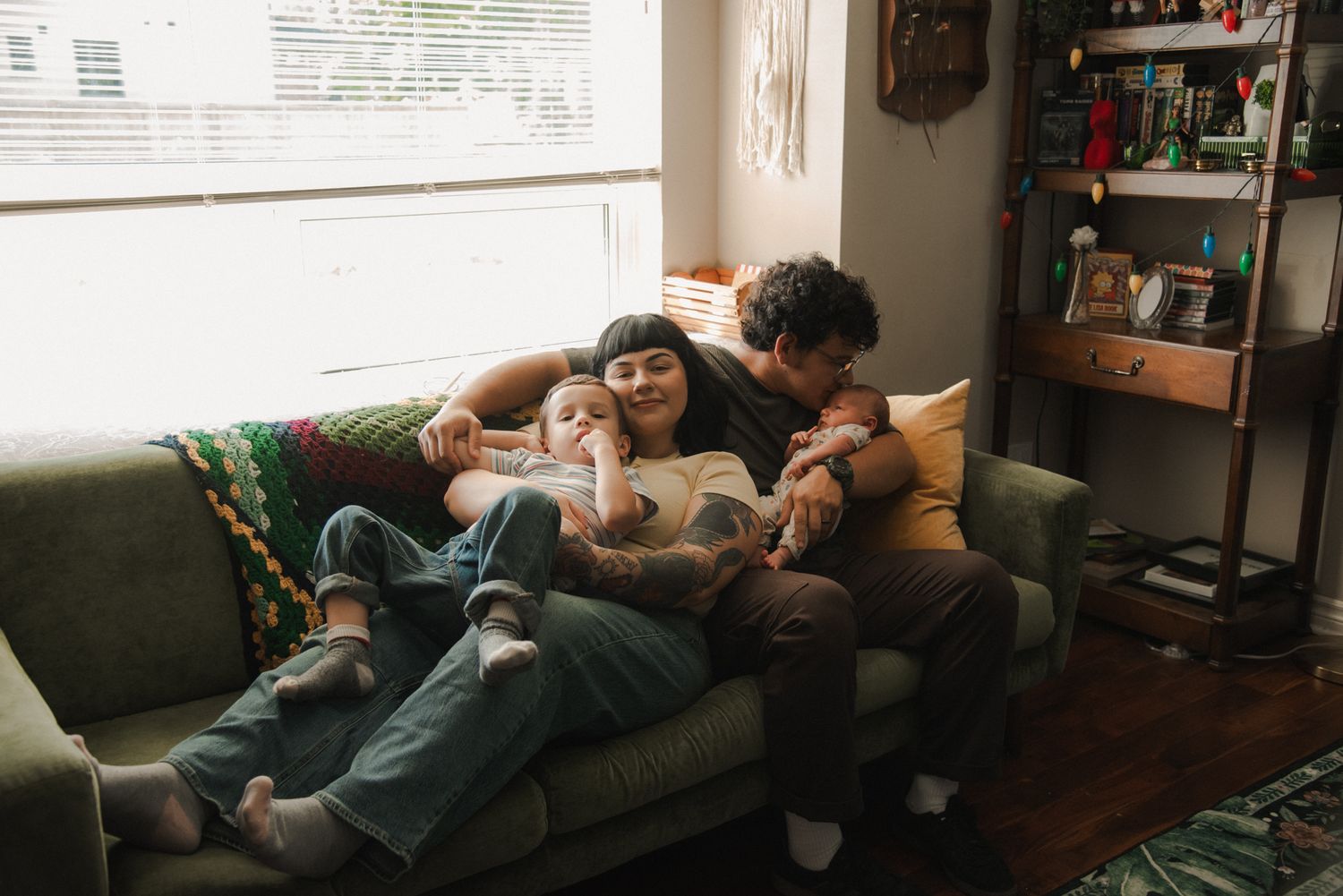 Family cuddling together on the couch during a candid in-home family photography session in St. Catharines, Ontario