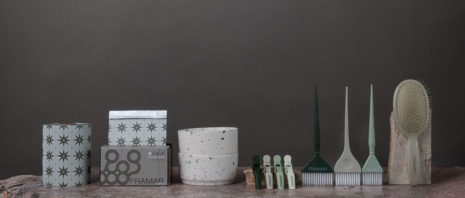 Studio product photography of Framar hair tools and foil packaging styled in neutral sage tones on a minimal, textured backdrop.
