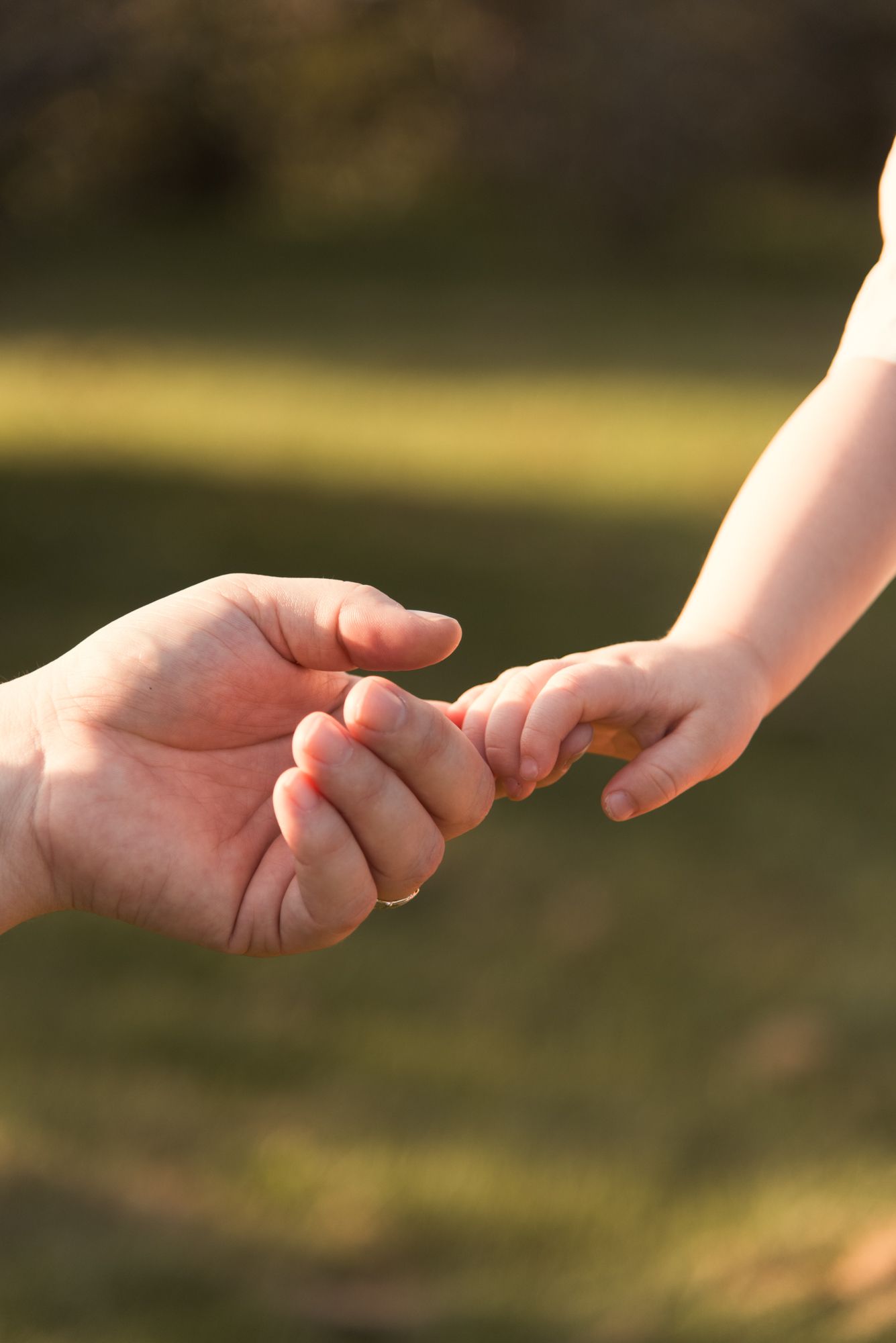 Close-up of a young boy reaching for his parent’s hand during a candid Niagara Falls family photography session