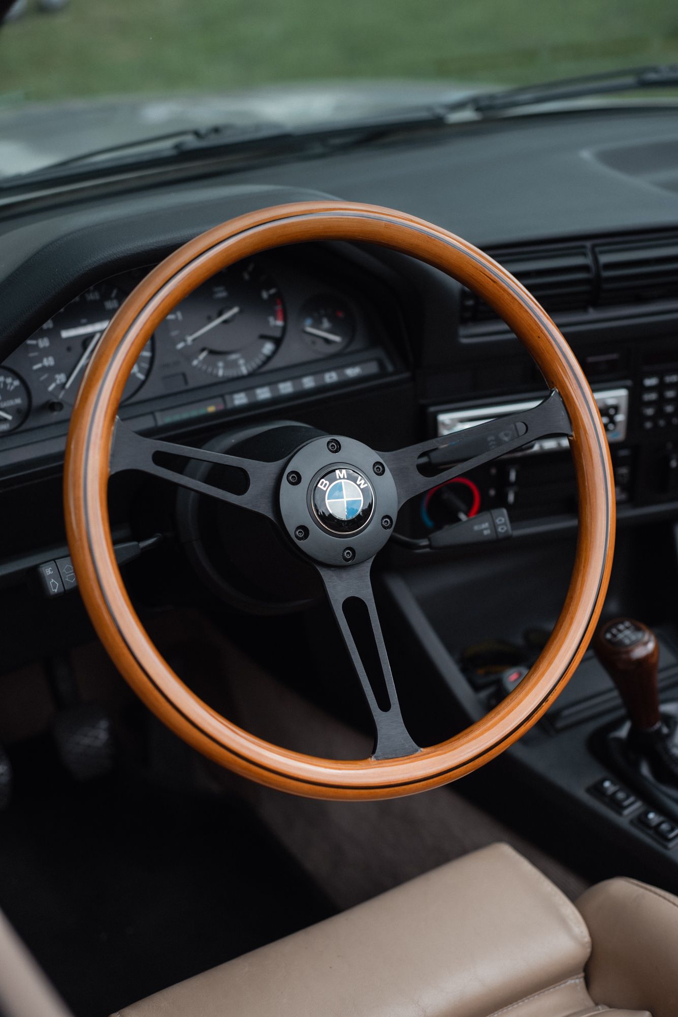 Classic BMW interior featuring a wood steering wheel and vintage dashboard.