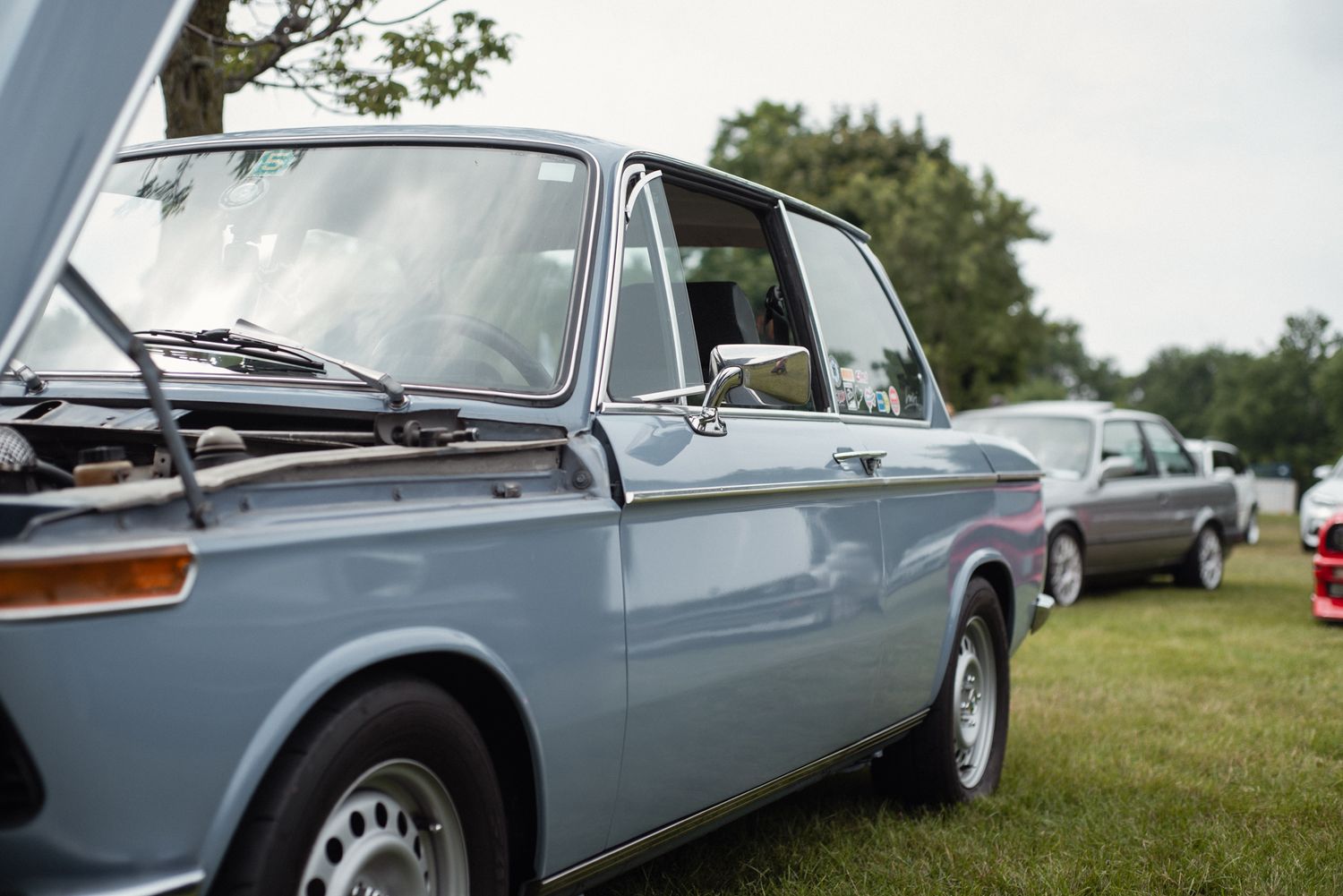 Light blue vintage BMW parked among classic cars at TedFest.