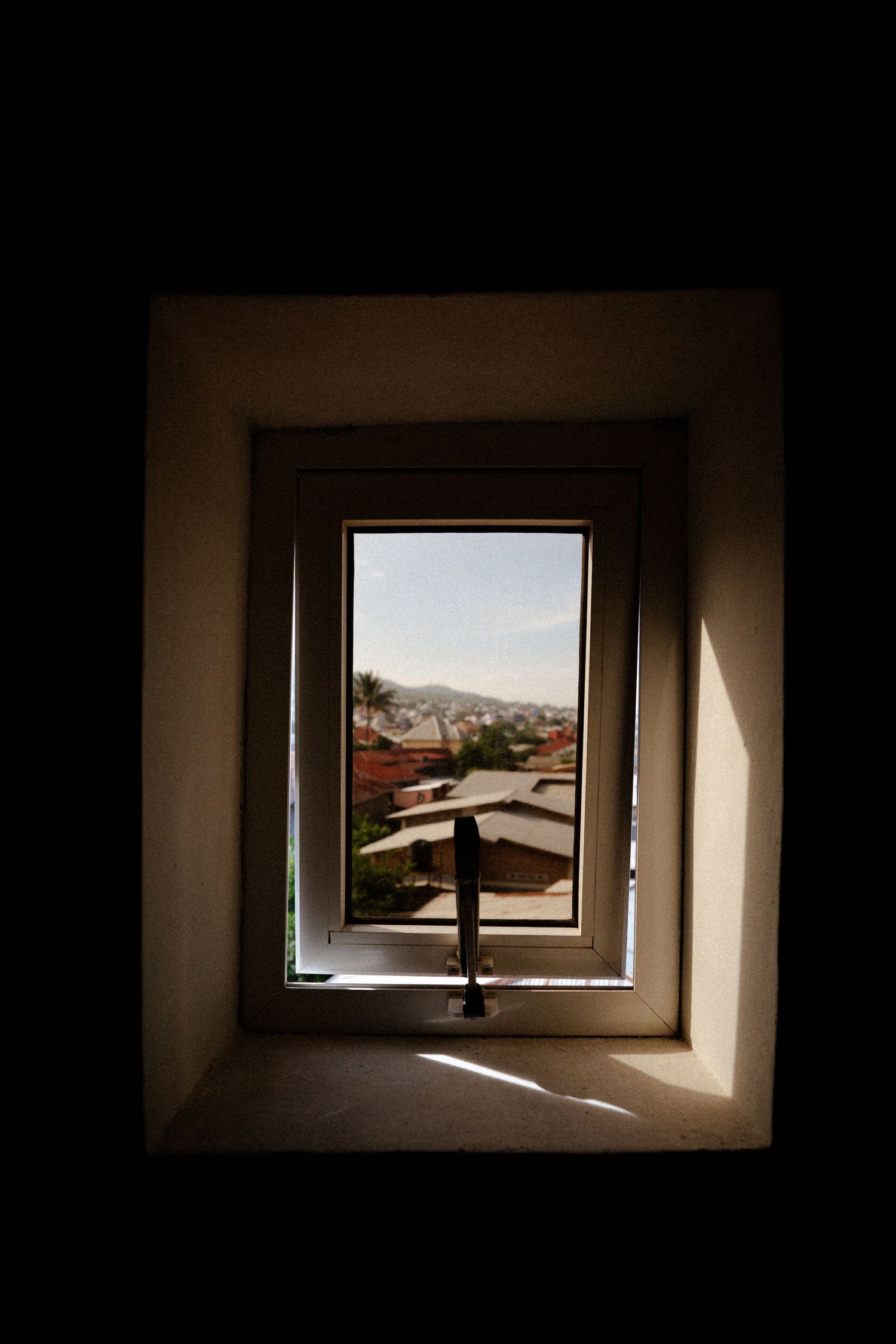 Sunlight streaming through small windows in a dark interior space.