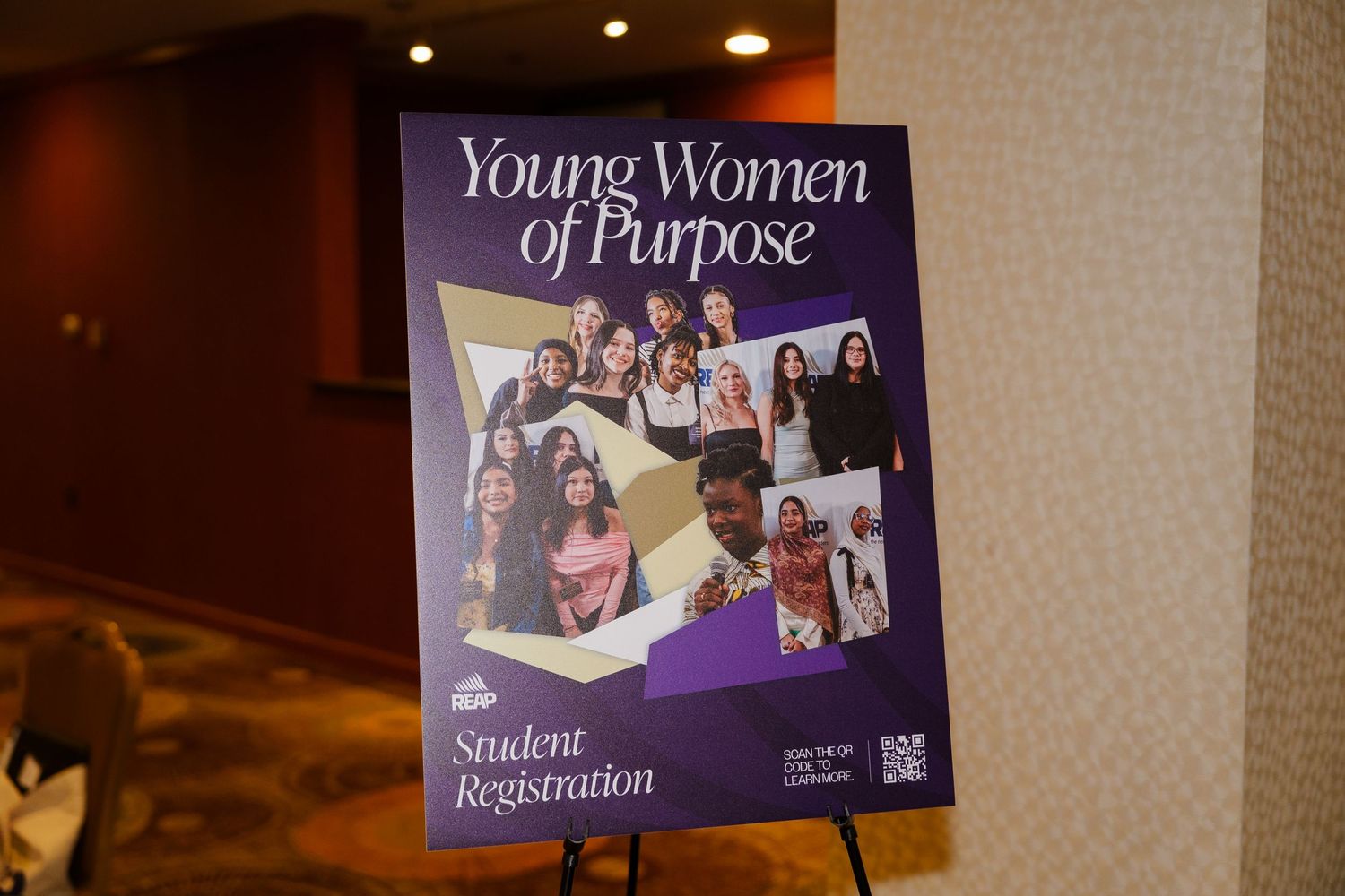Young Women of Purpose student registration sign with collage of diverse women at an empowerment event.