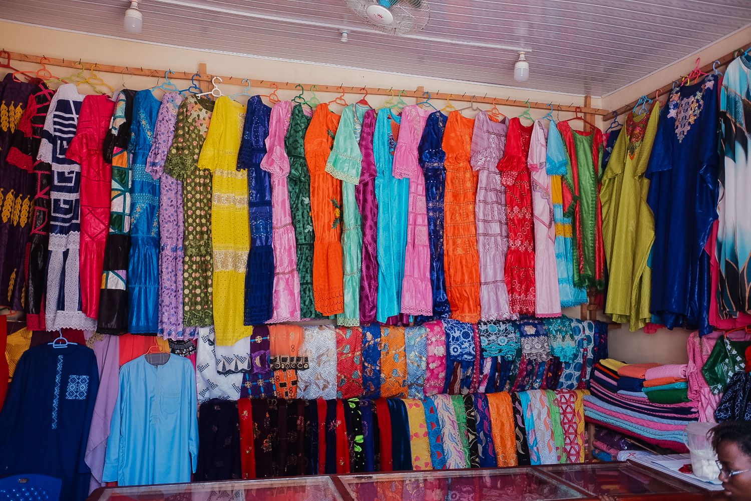 Colorful display of clothing hanging in a retail store with bright shirts in various hues.