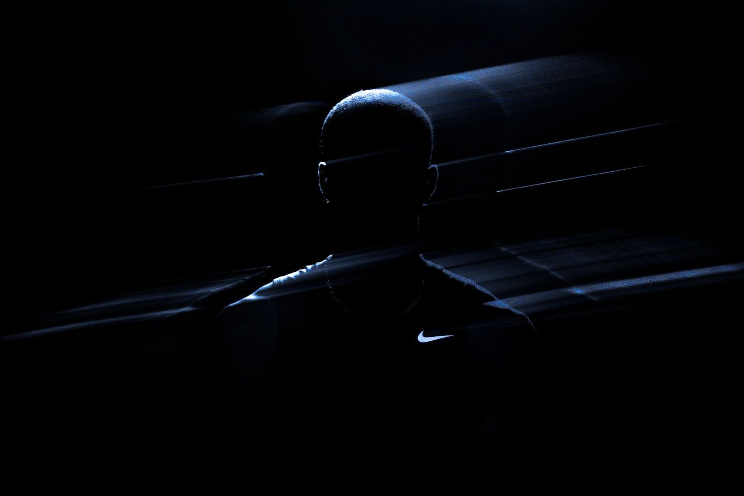 Minimalist black and white photo showing silhouette of athlete in dramatic lighting.