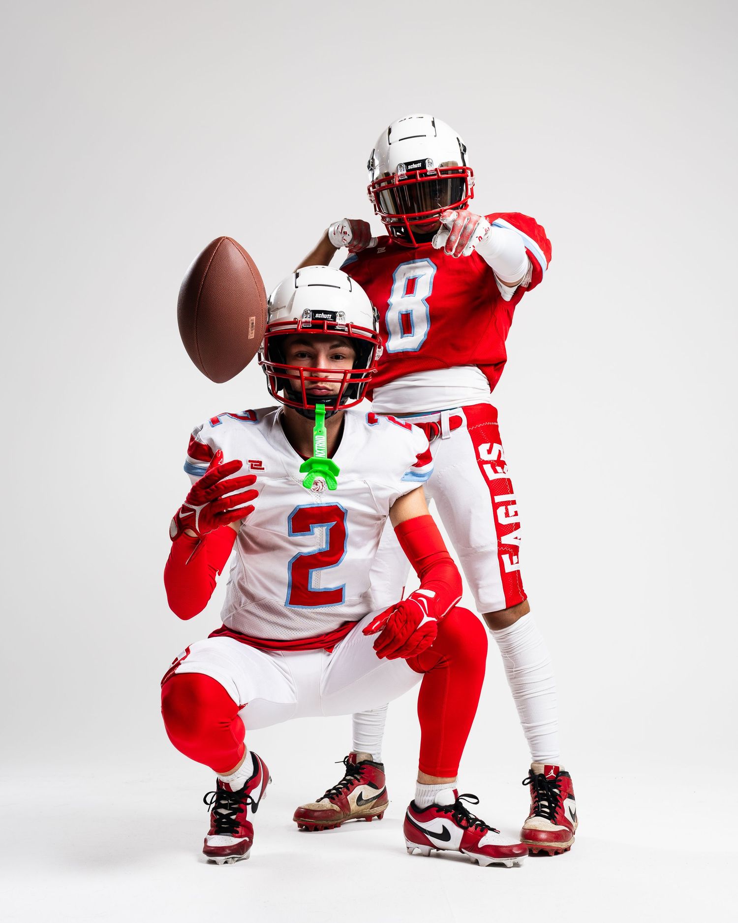 Football players in red and white uniforms demonstrate crouching positions.