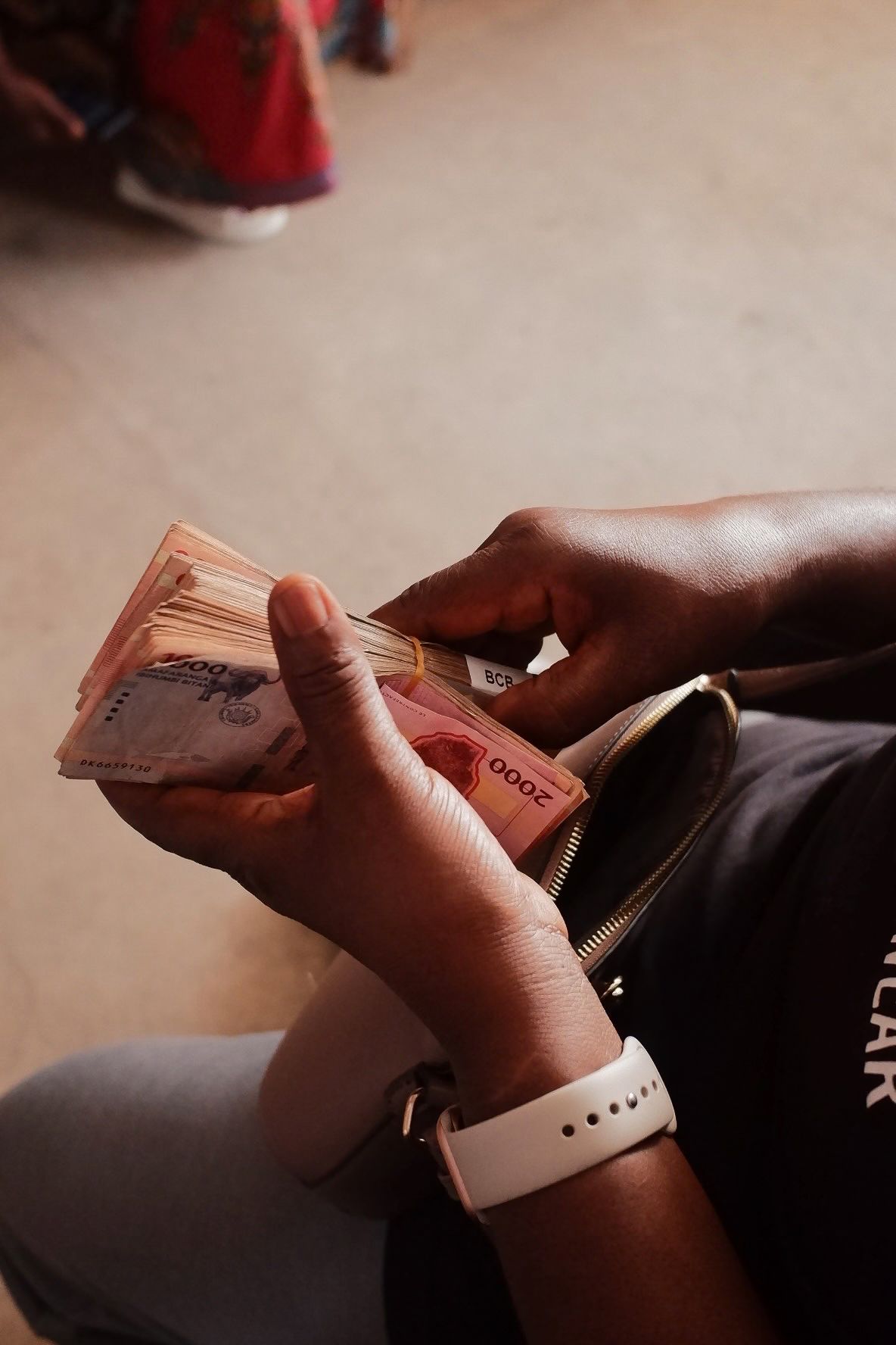 Hands counting money and handling currency notes.