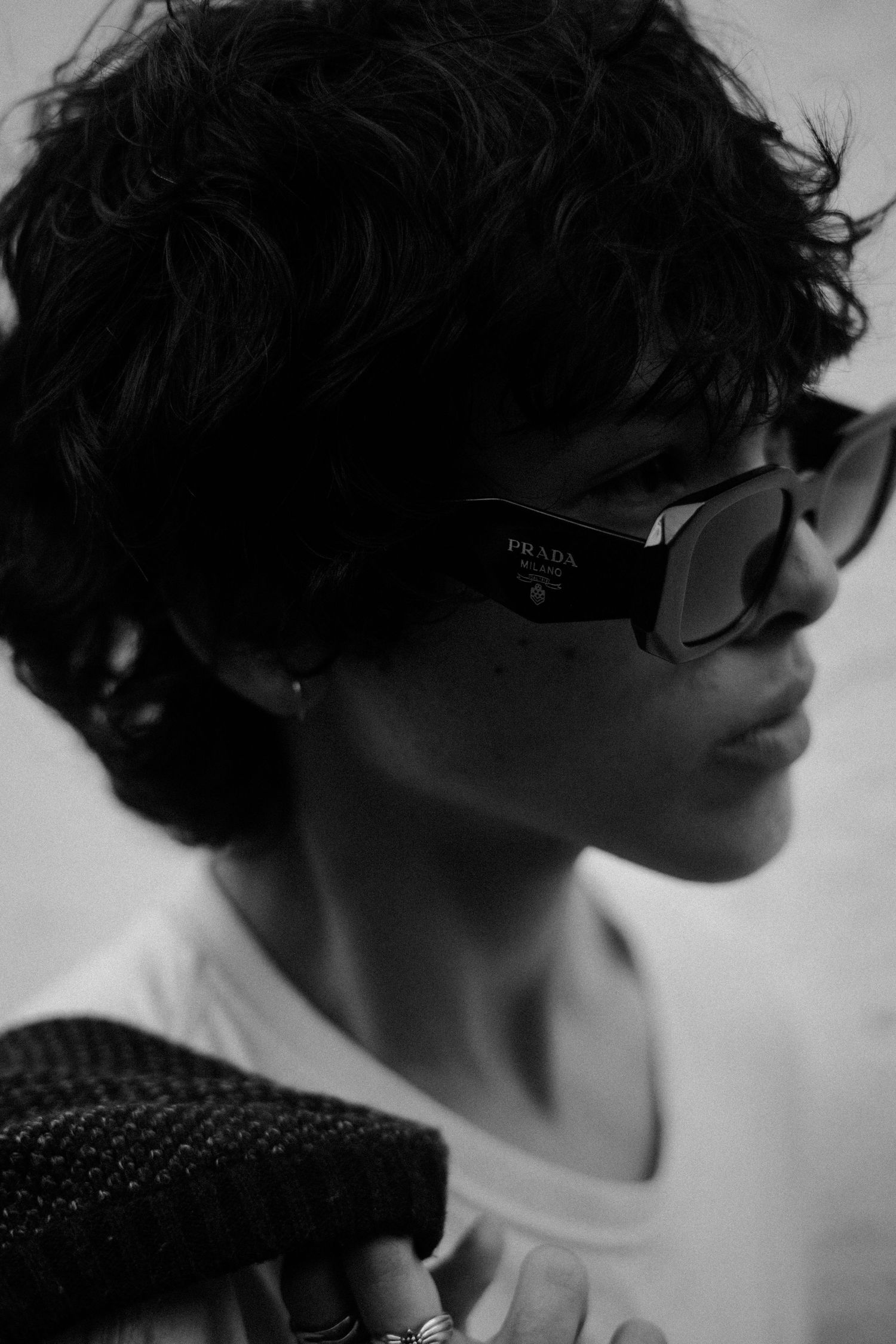 Stylish profile shots showing designer sunglasses and curly hair in black and white.