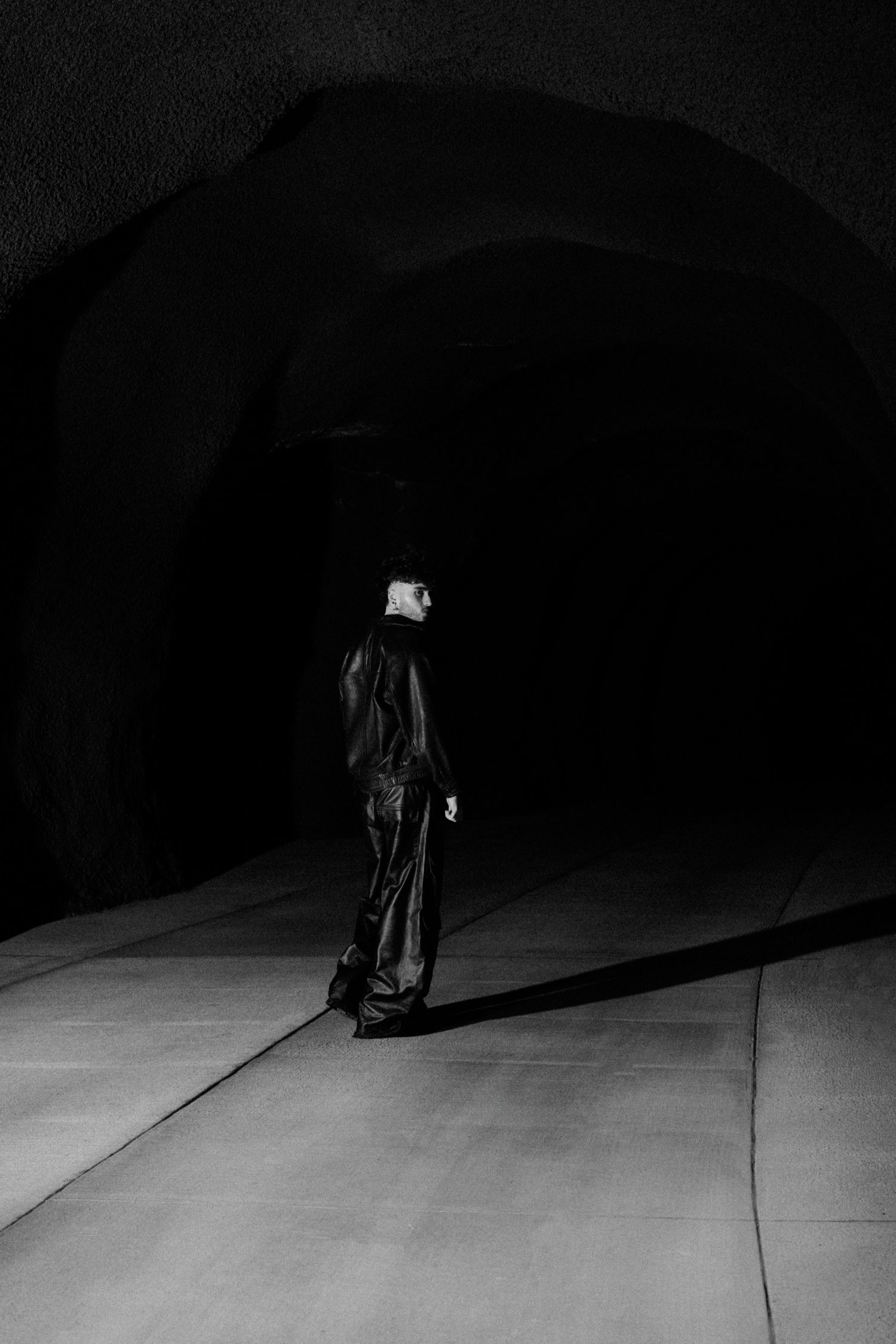 Dark artistic composition showing figure crawling across shadowy floor.