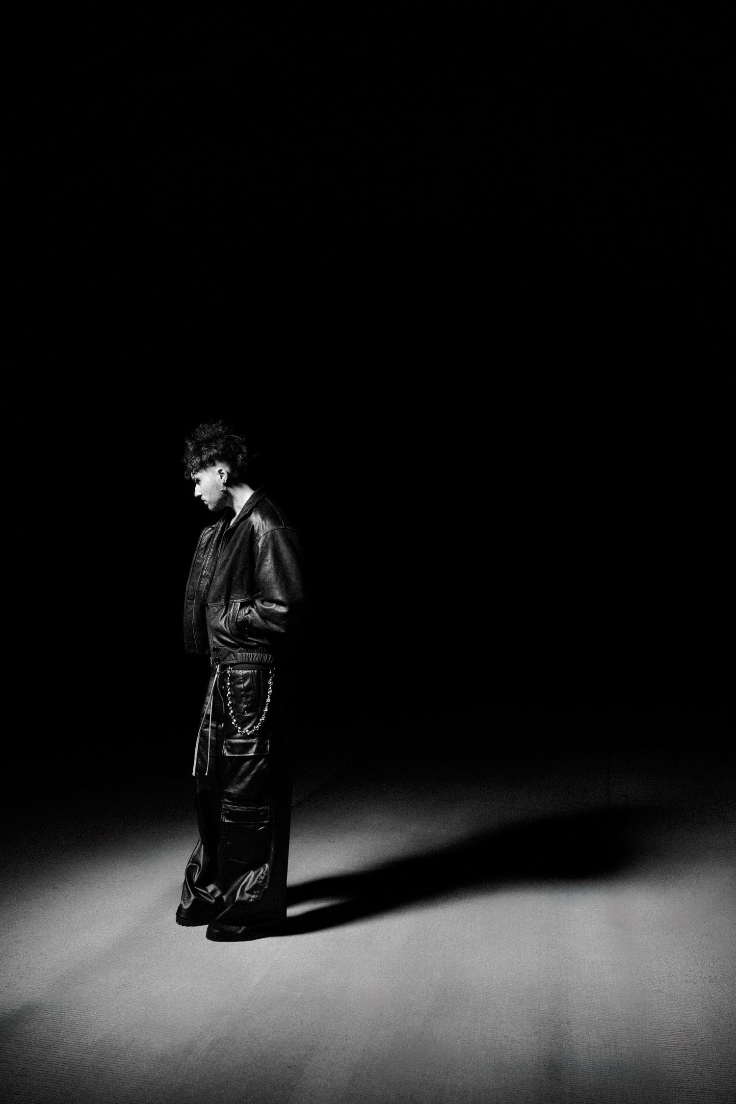 Dramatic black and white portrait series showing a figure emerging from shadows on a dark stage.