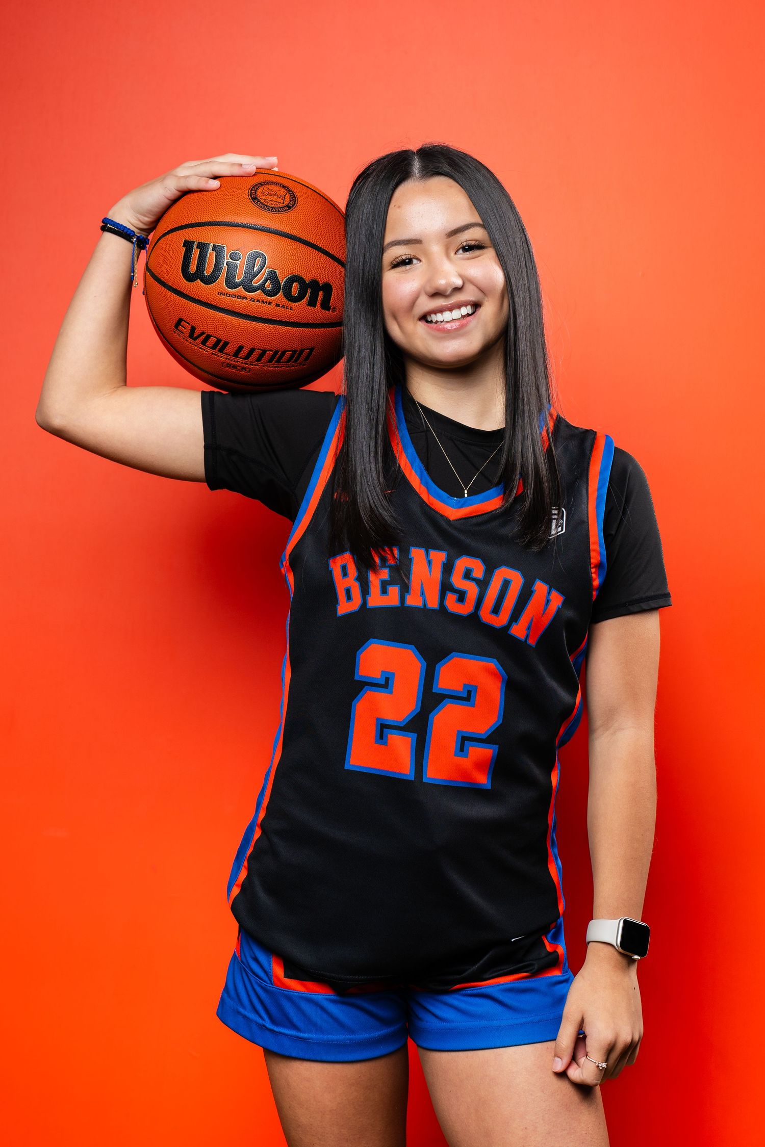 Player wearing Benson #22 jersey poses with basketball against red background.