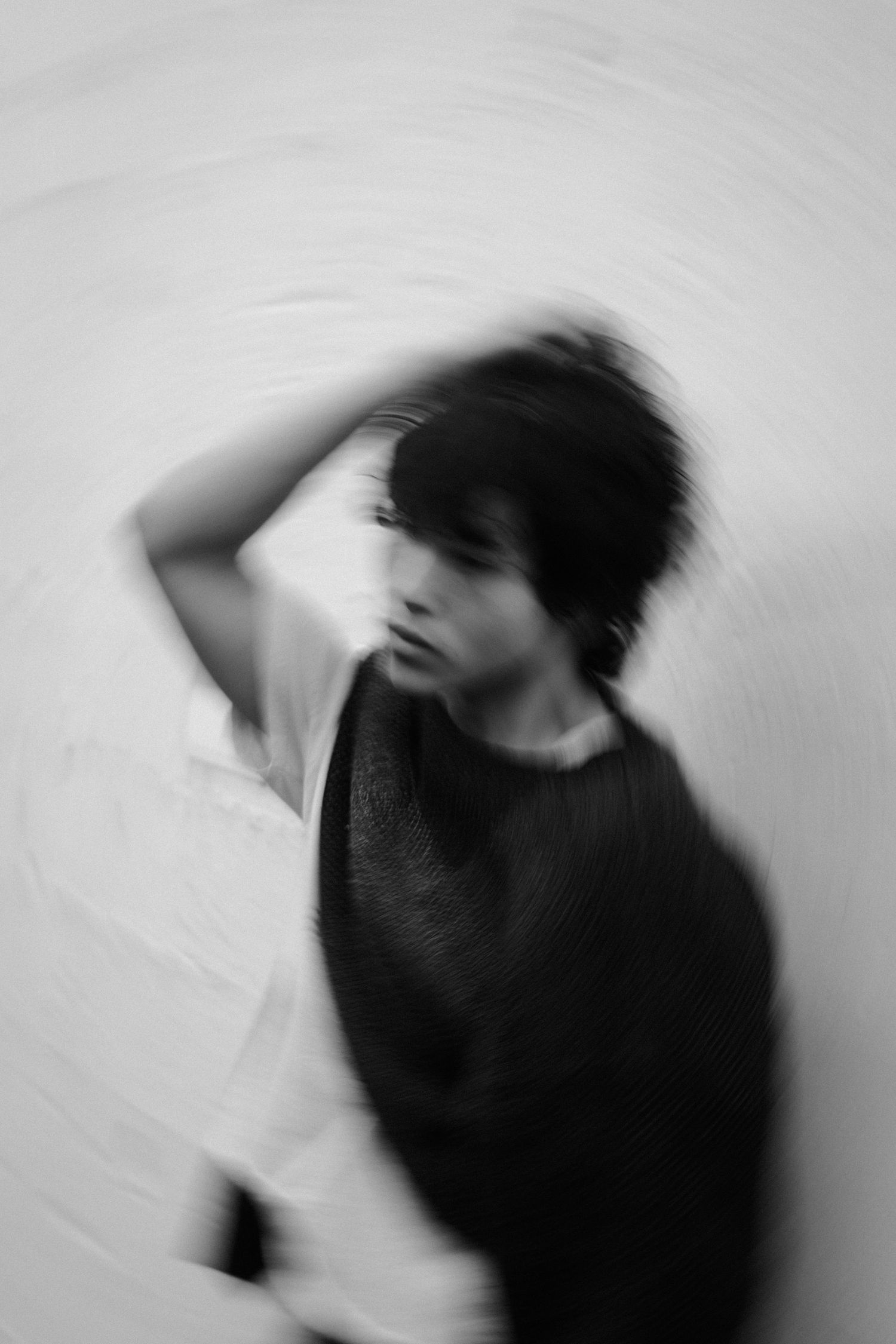 Blurred figure in monochrome creates abstract dance-like movement sequence.