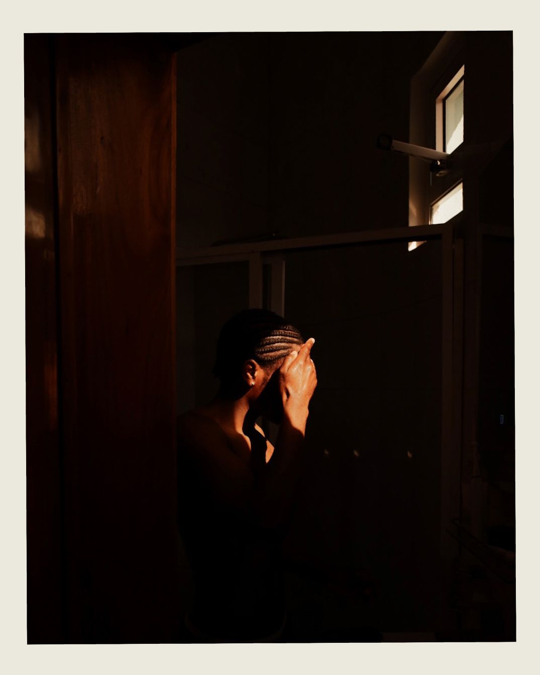Dark atmospheric portrait with dramatic shadows and lighting creating a moody silhouette effect.