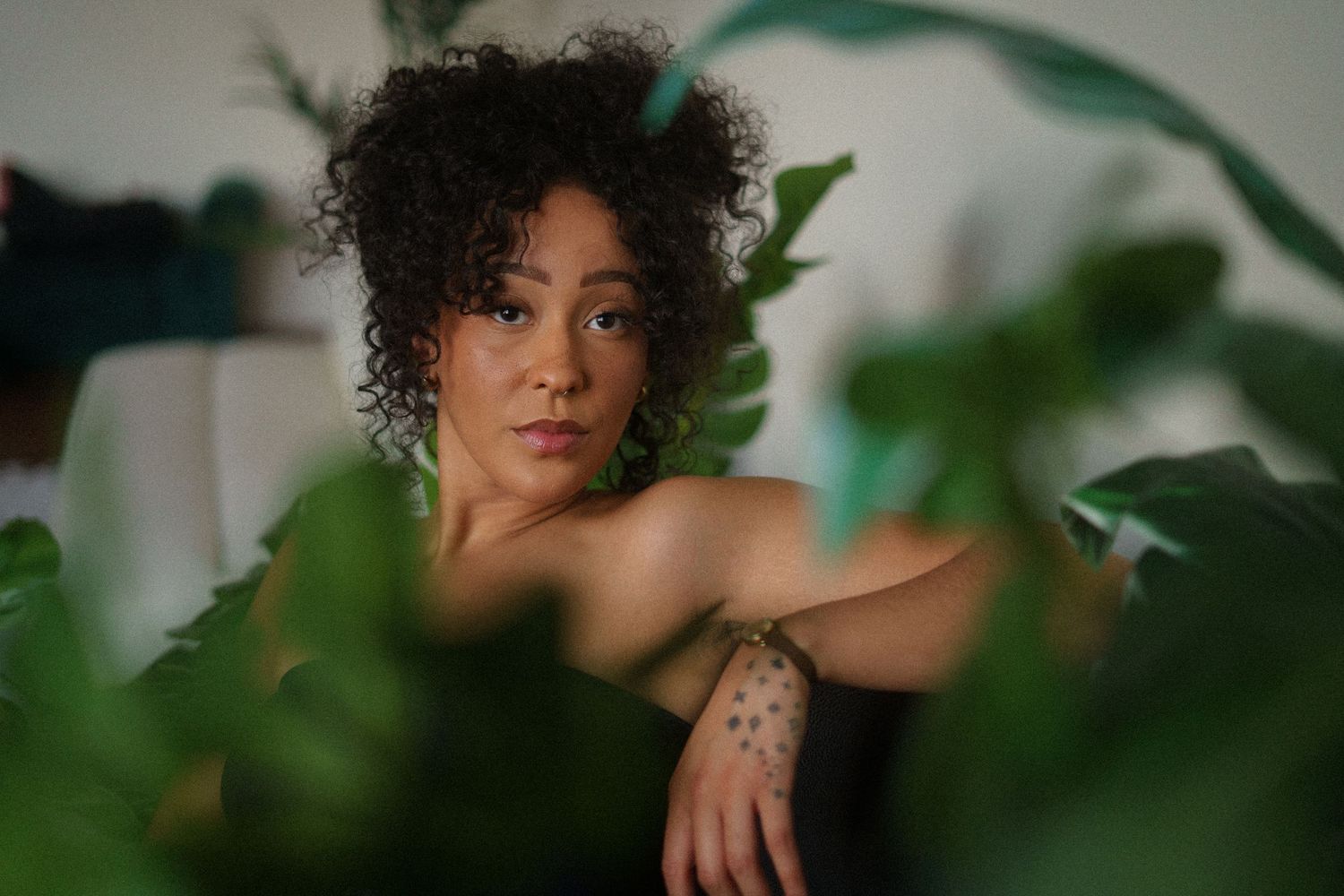 Artistic portrait sequence framed with green plants and natural lighting.