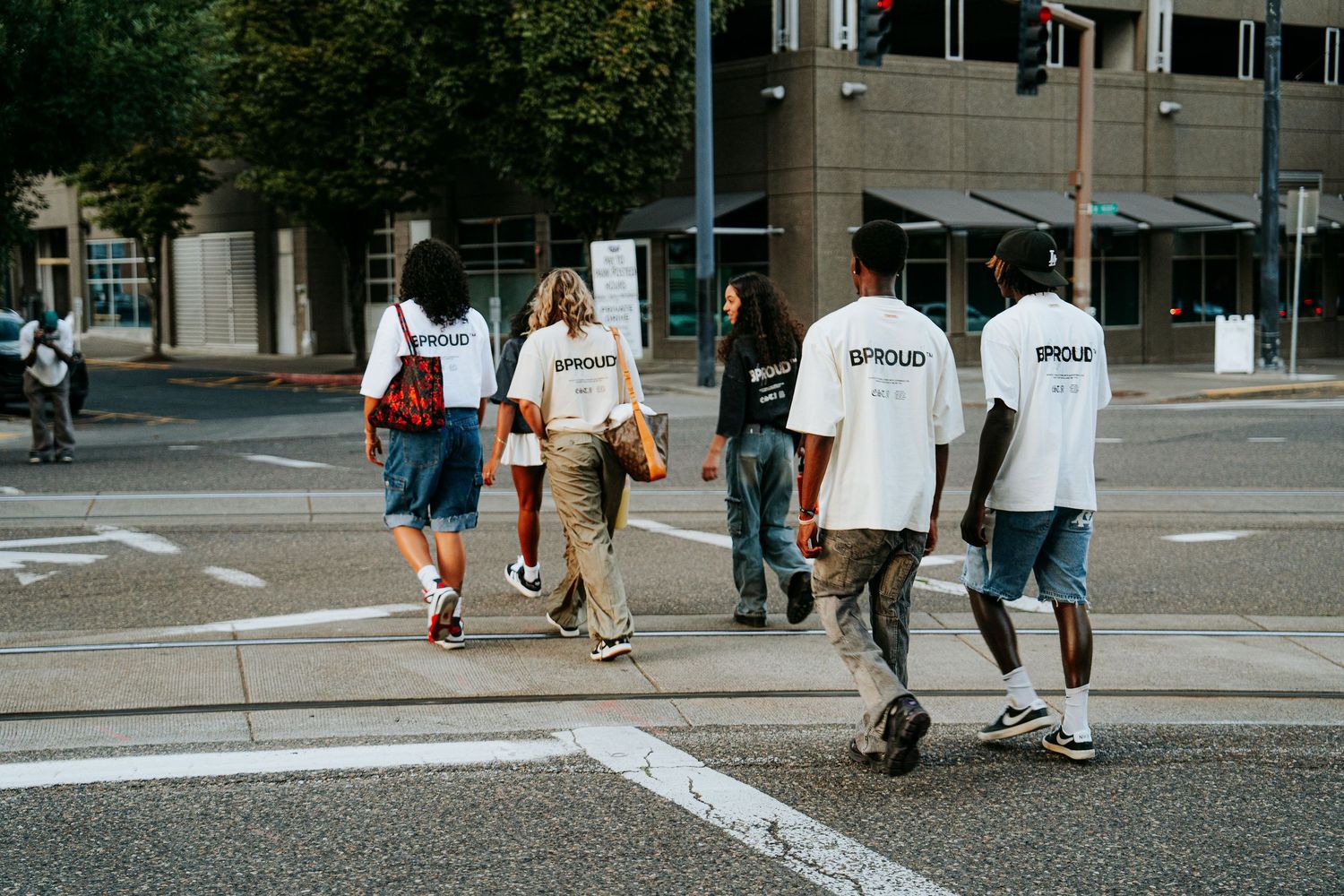 Students walking across a college campus plaza with backpacks and casual attire on a sunny day.