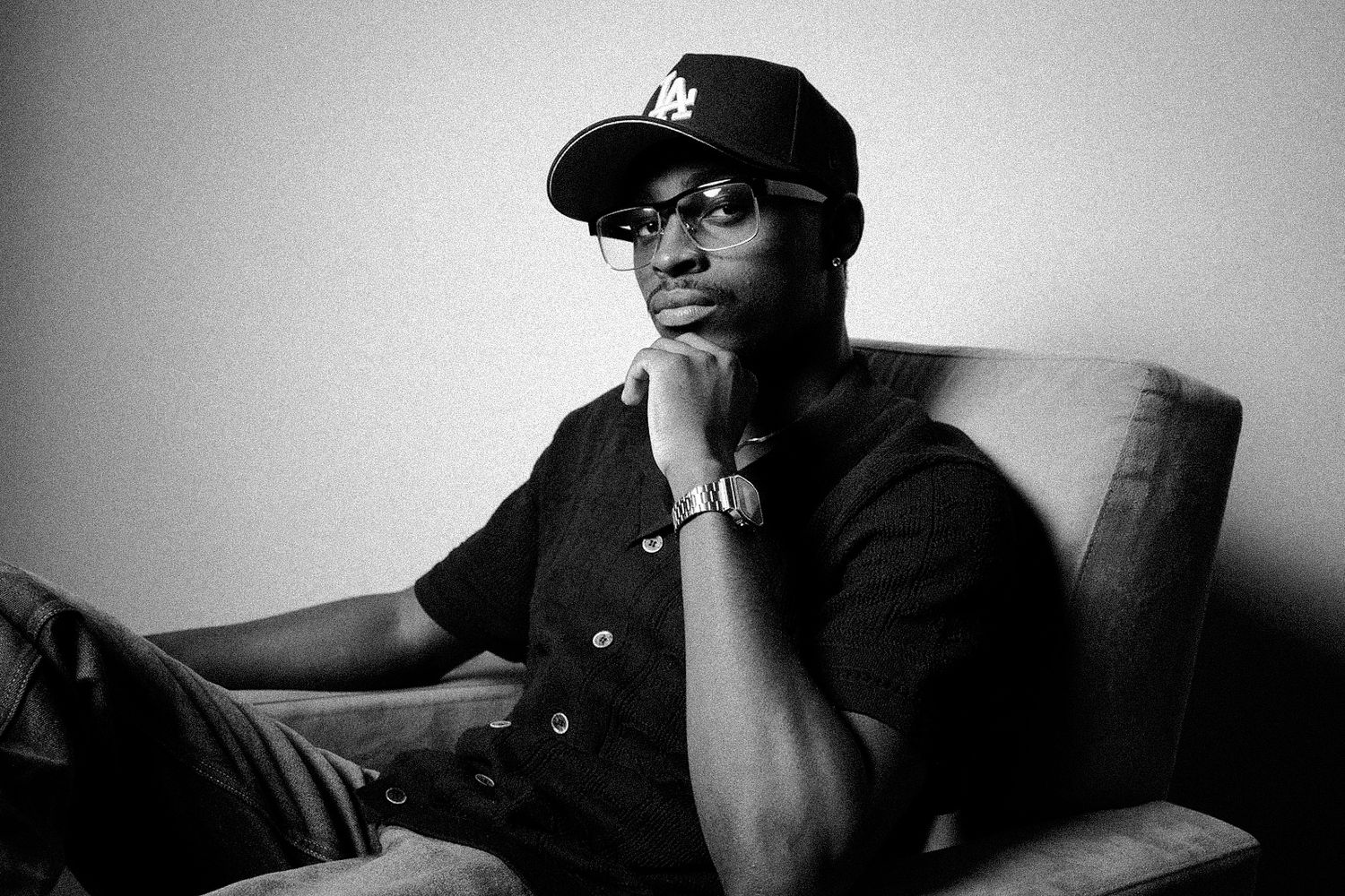 Moody black and white portrait series with dramatic shadows and baseball cap.