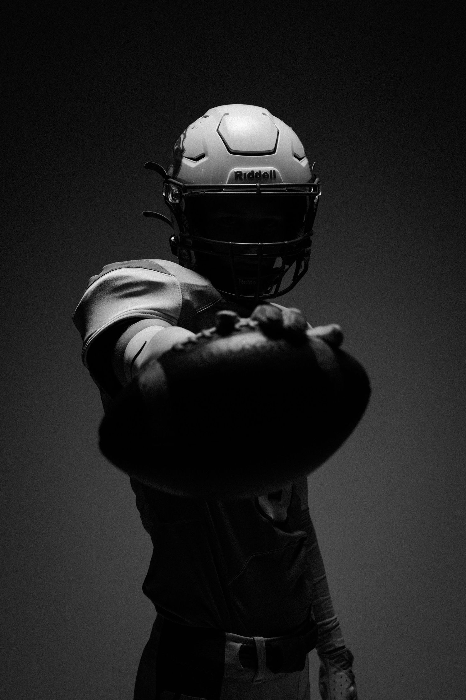 Dramatic black and white portraits of football players in protective gear.