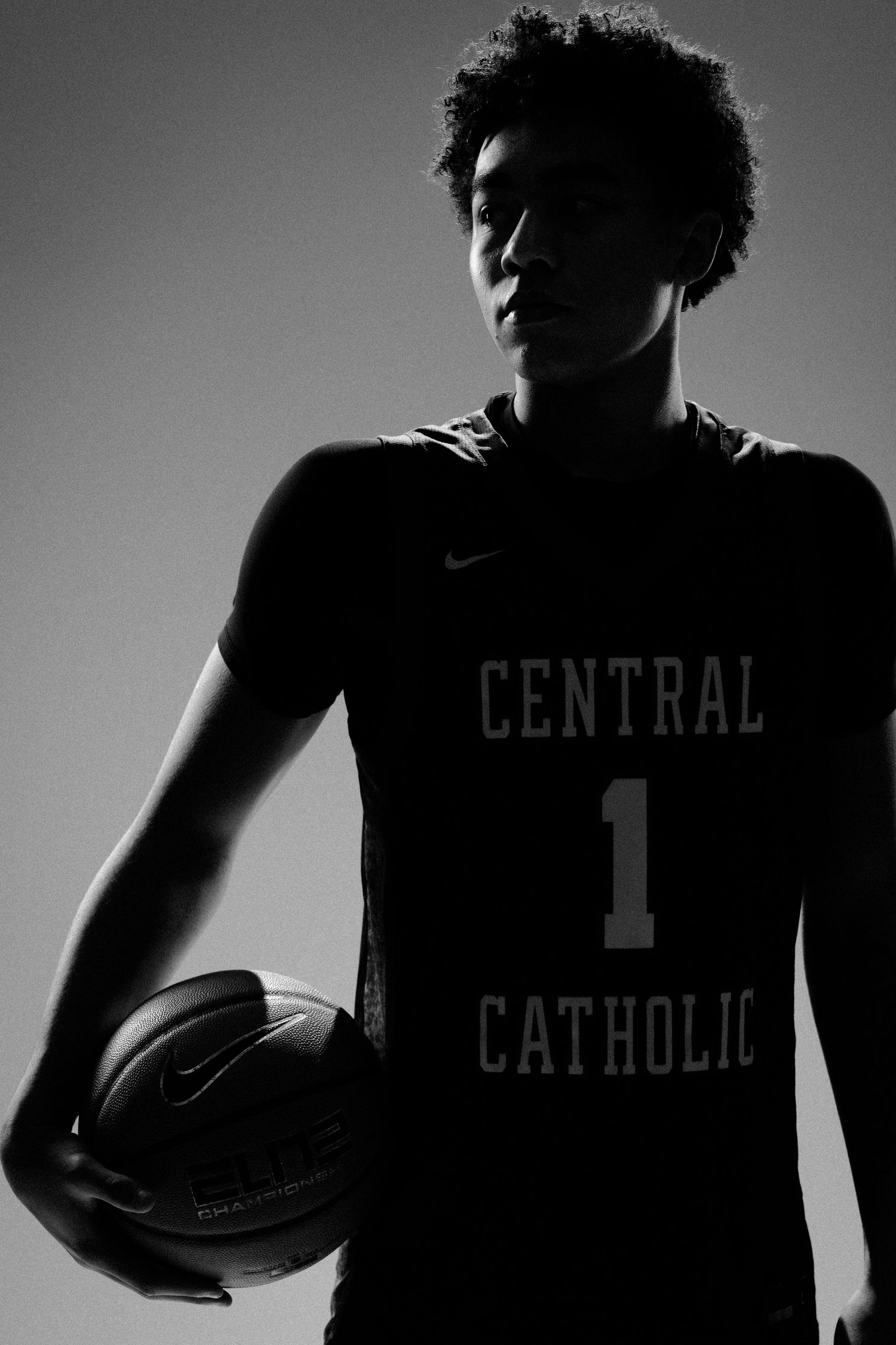 Basketball player in Central Catholic jersey number 1 shown in dramatic shadow profile.