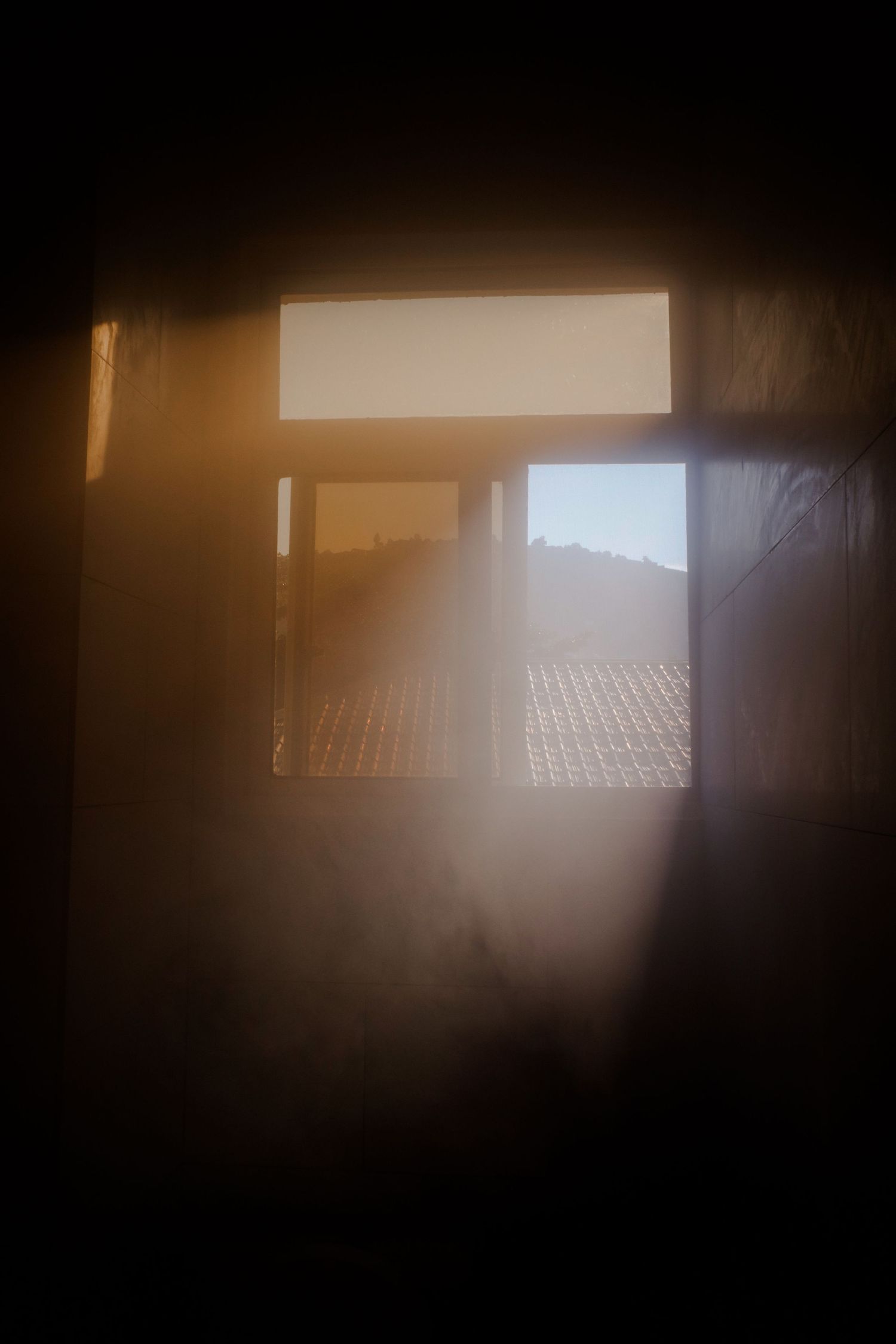 Series of window views showing sunlight streaming through dark interior spaces.