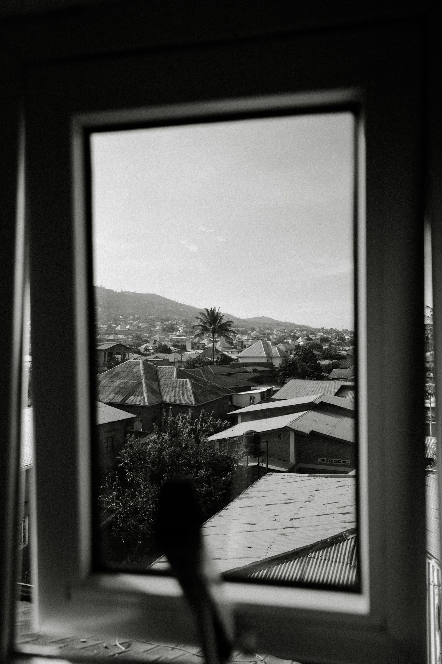 Black and white landscape views through windows showing rooftops and mountains.