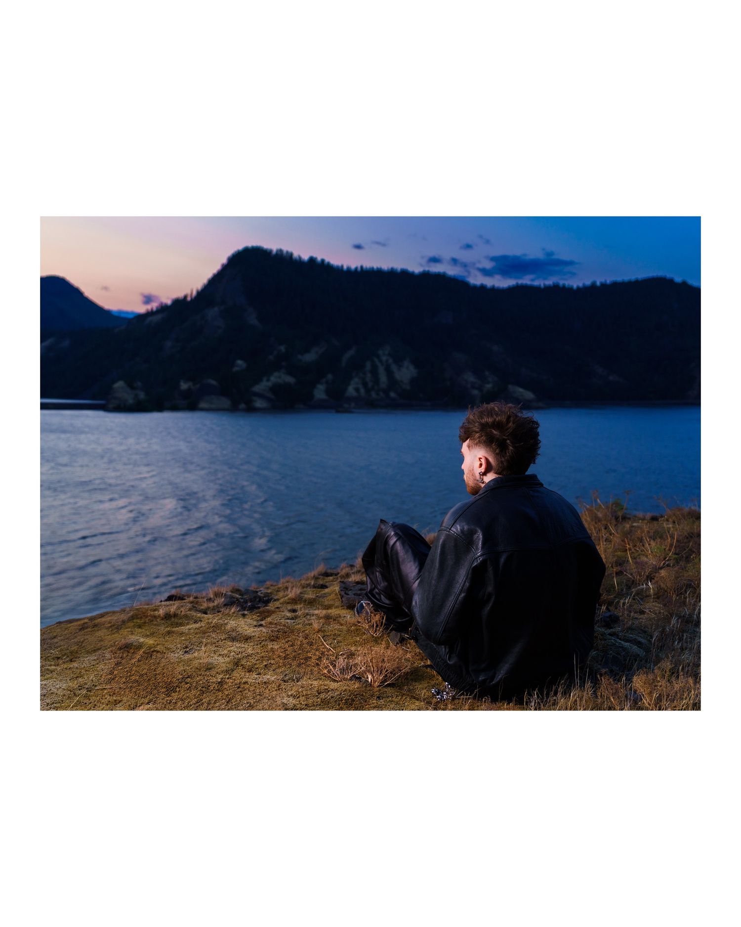 Scenic mountain landscape with lake view at sunset showing silhouetted figures.