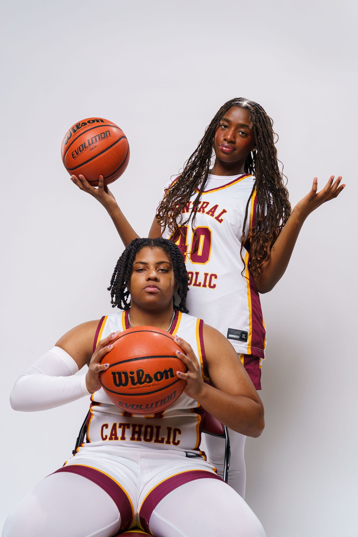 Basketball players in white Central Catholic uniforms pose with Wilson basketballs.