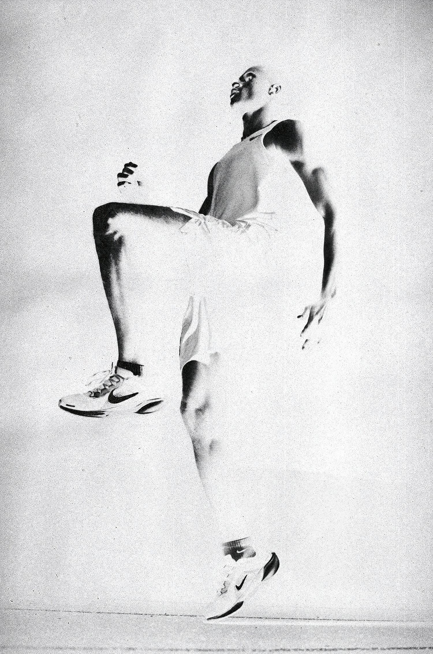 Black and white photo of an athletic man mid-stride, wearing Nike sneakers and athletic wear, captured in dynamic motion.