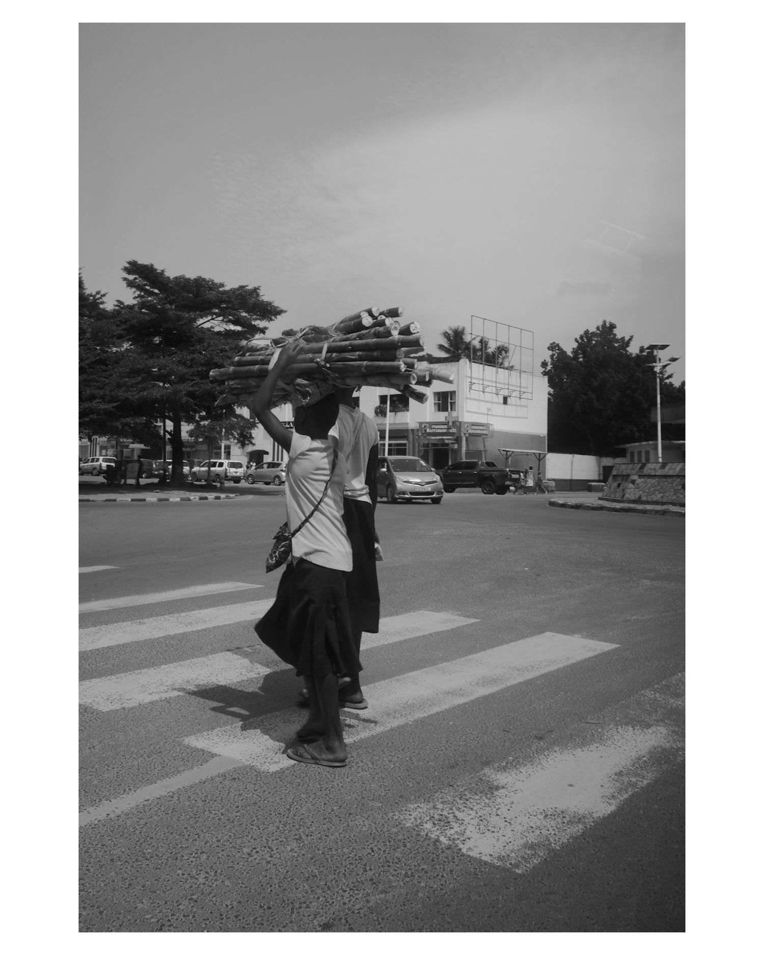People crossing a zebra crossing on a street in black and white photography.