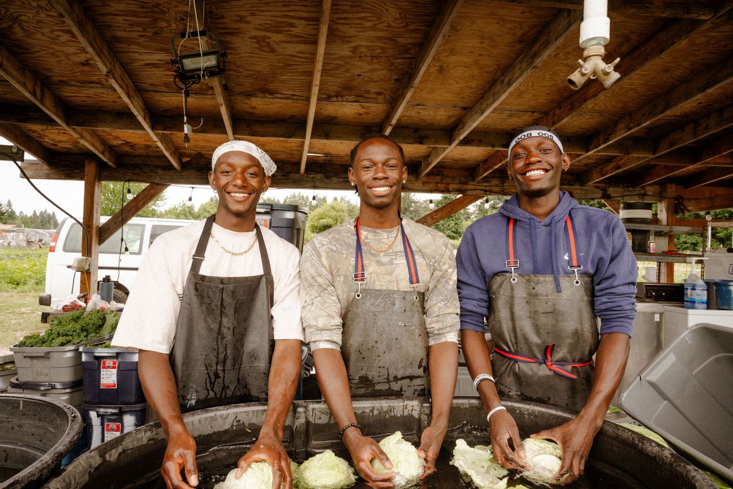 Group working together at an outdoor cooking station with professional equipment.