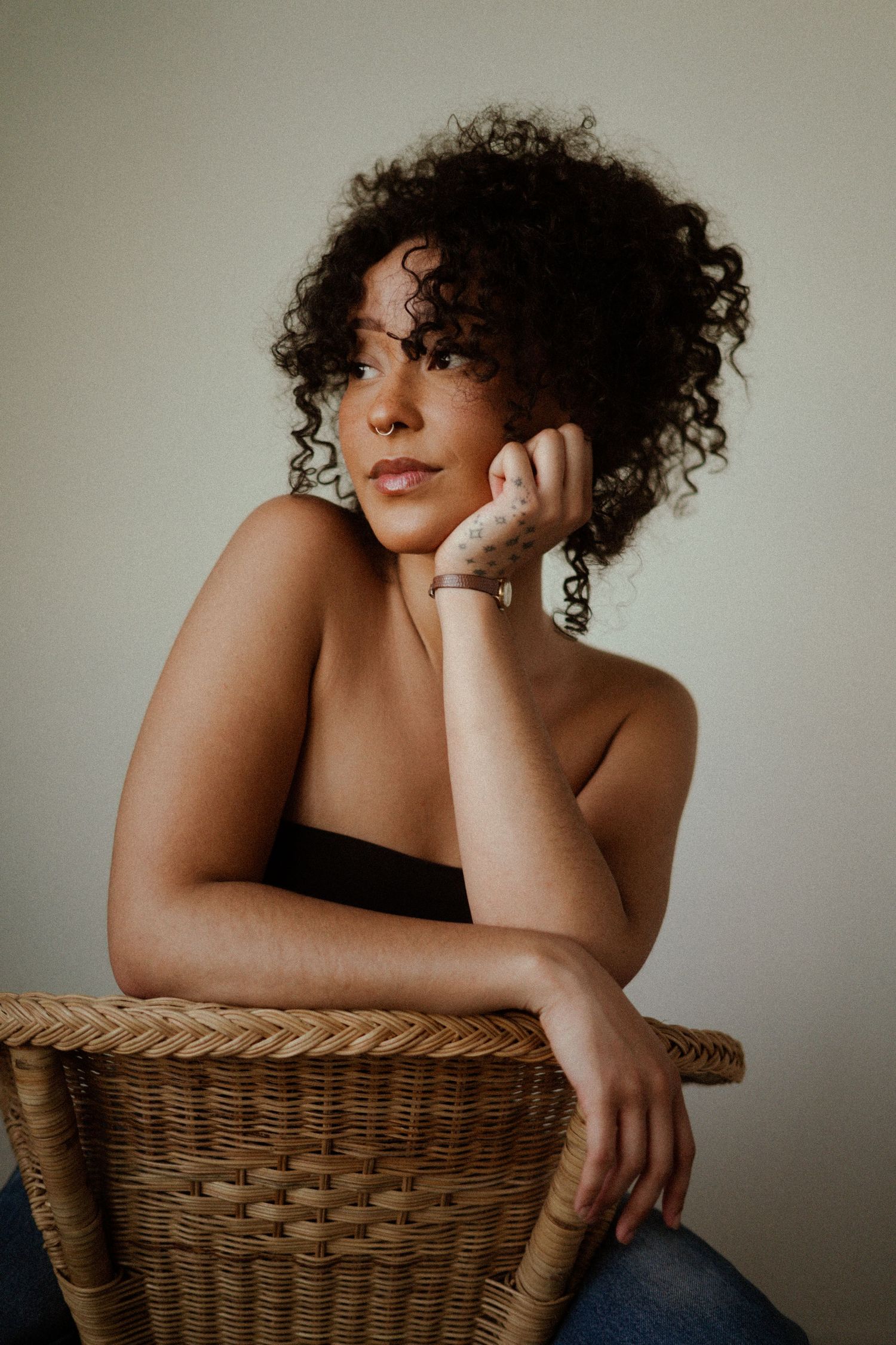 Minimalist portrait series featuring poses with a woven wicker chair.