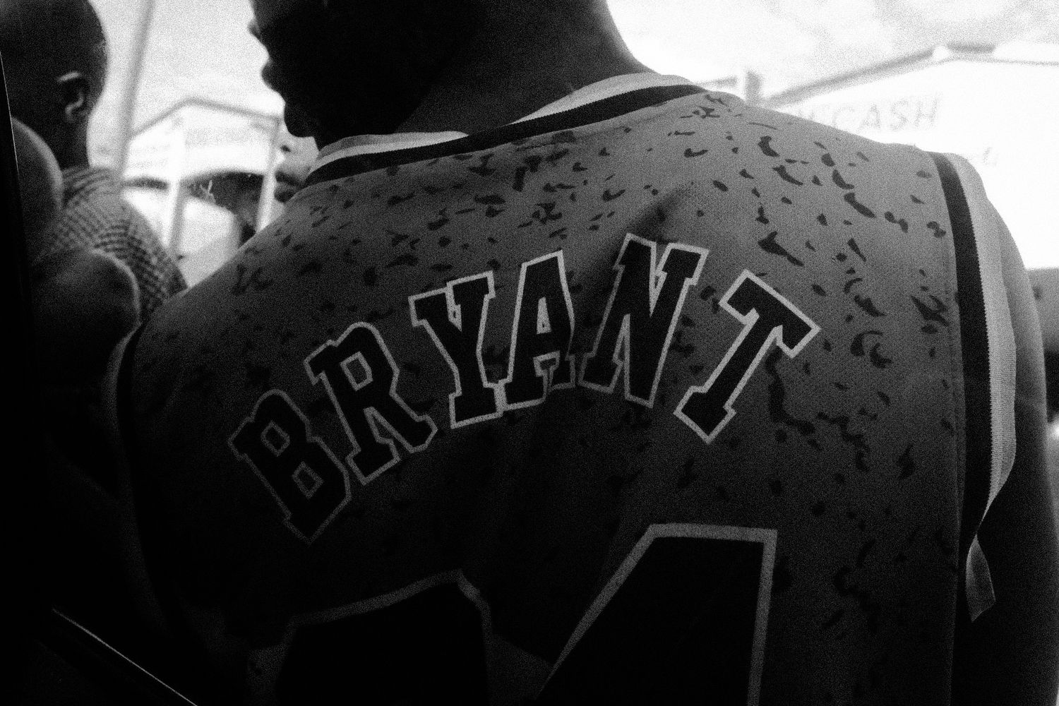 Close-up view of a black jacket with text visible on the back in low light.