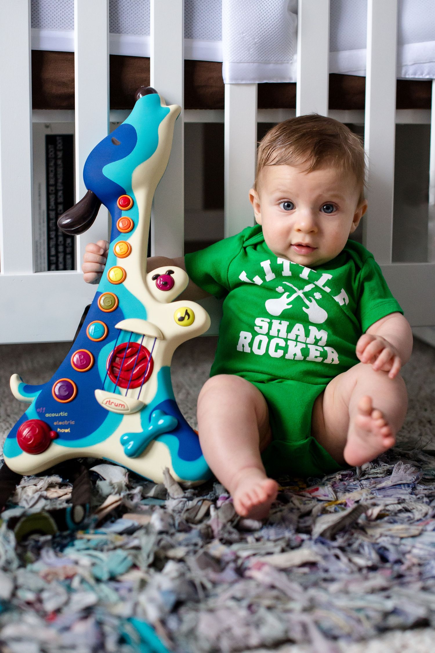 Baby in green shirt sits on gray carpet with colorful toy guitar in progressive sequence of four photos.