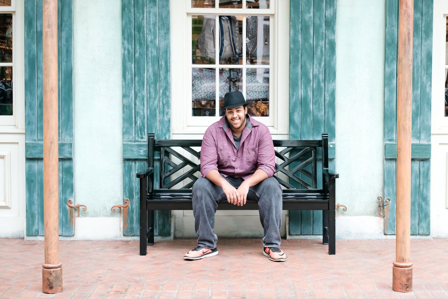 Architectural series showing person sitting on bench outside historic building with teal shutters.