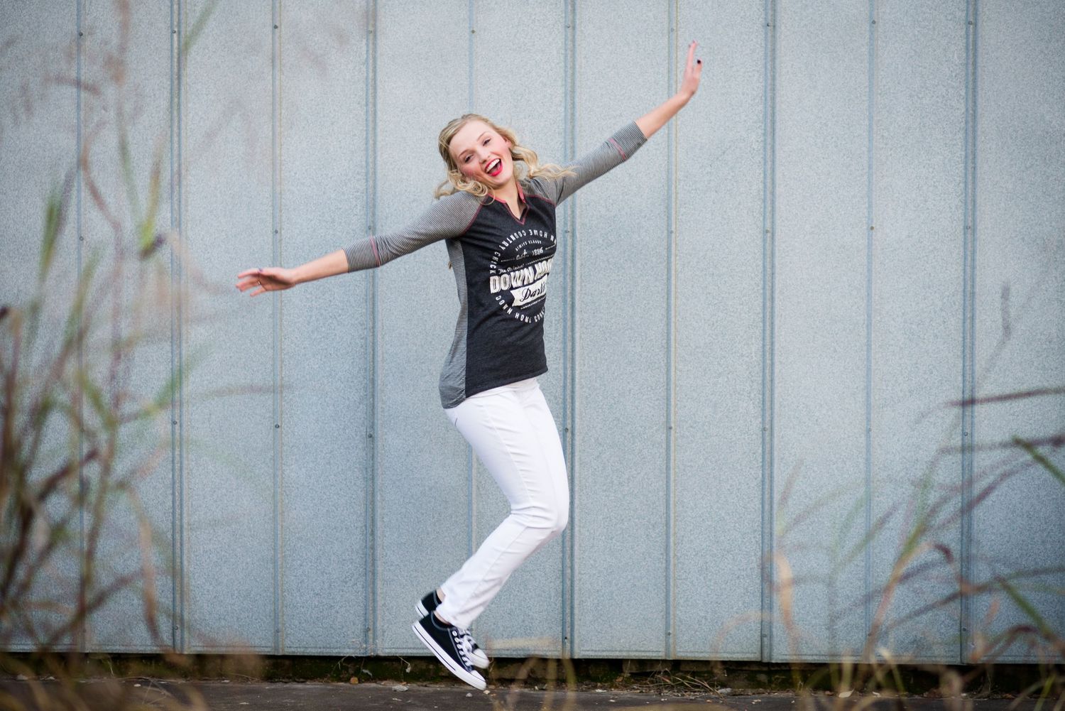 Series of energetic dance-like poses against a light blue wall background.
