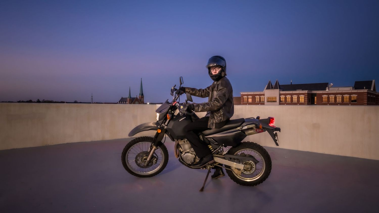 Vintage motorcycle silhouetted against a purple twilight sky.