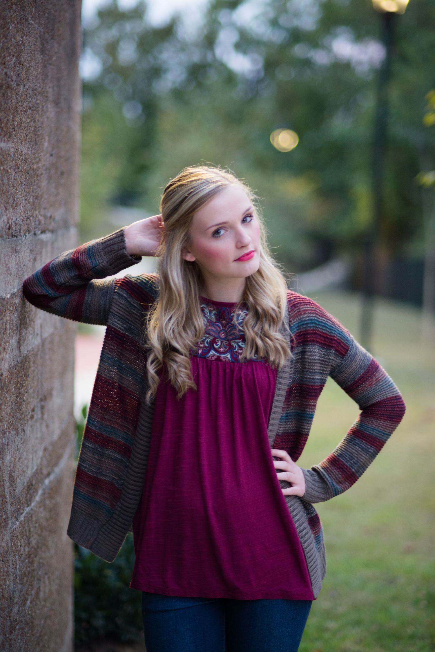 Fashion portrait series in burgundy top and plaid jacket against outdoor evening setting.