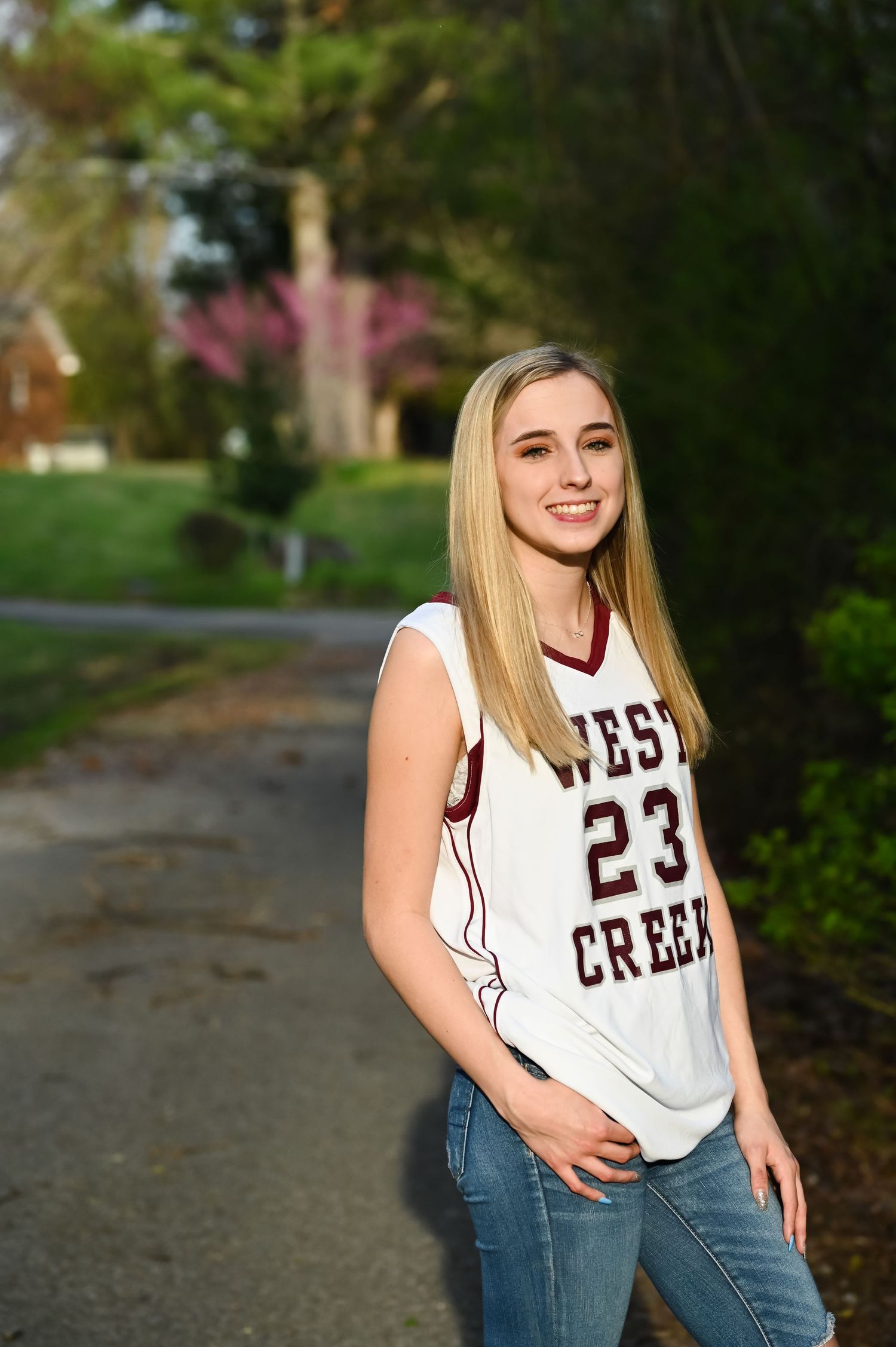 Sports-themed portrait series featuring varsity jersey and casual poses on outdoor path.