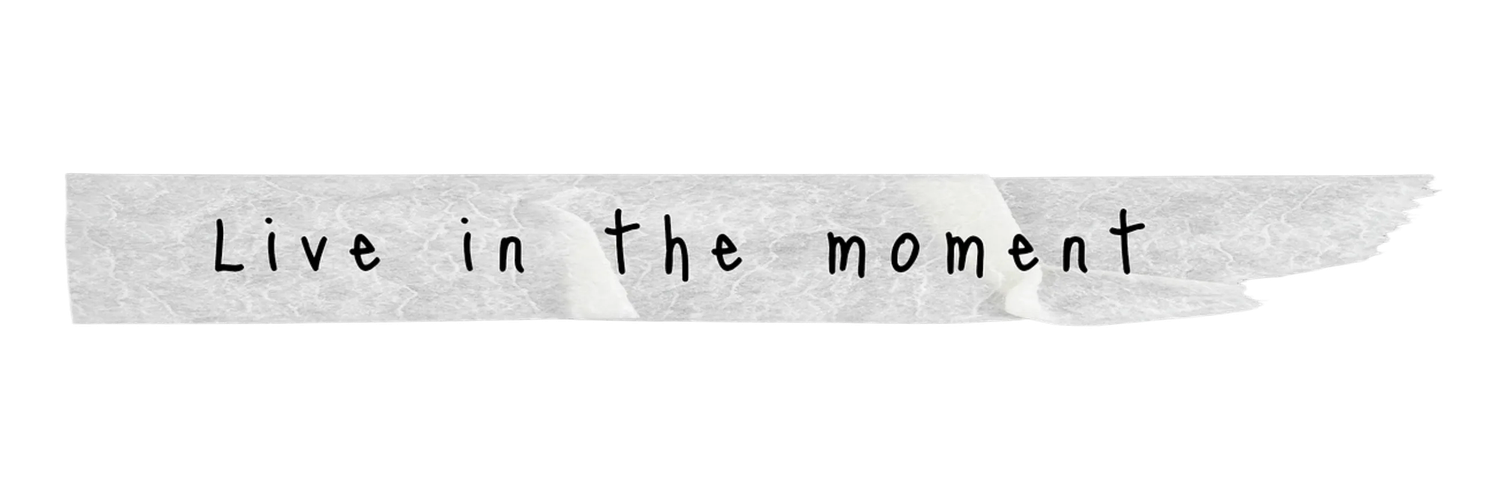 Handwritten inspirational quote Live in the moment on torn paper tape strip.