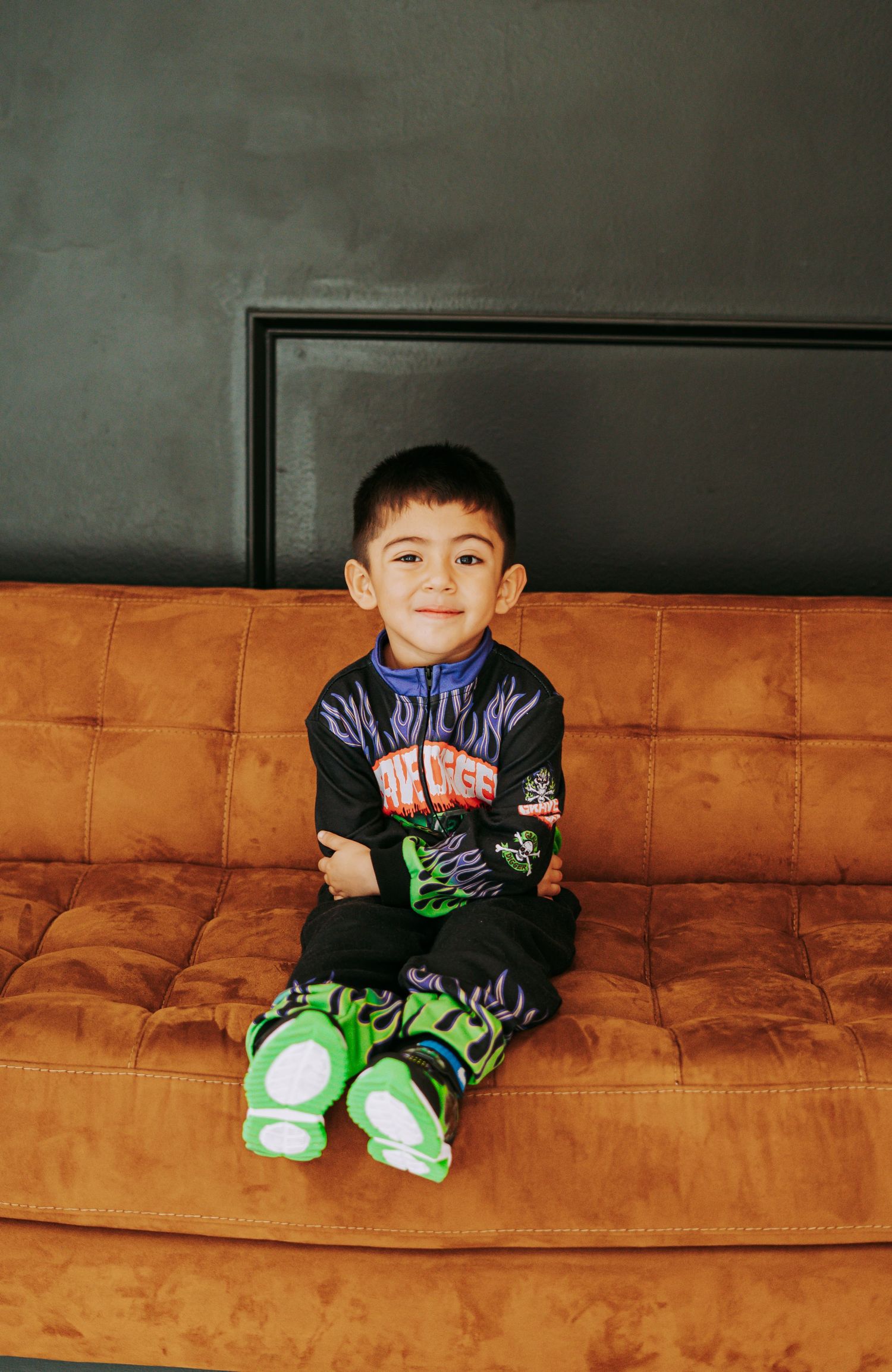 Close-up of boy wearing Monster Jam Grave Digger zip-up racing costume with flame details.