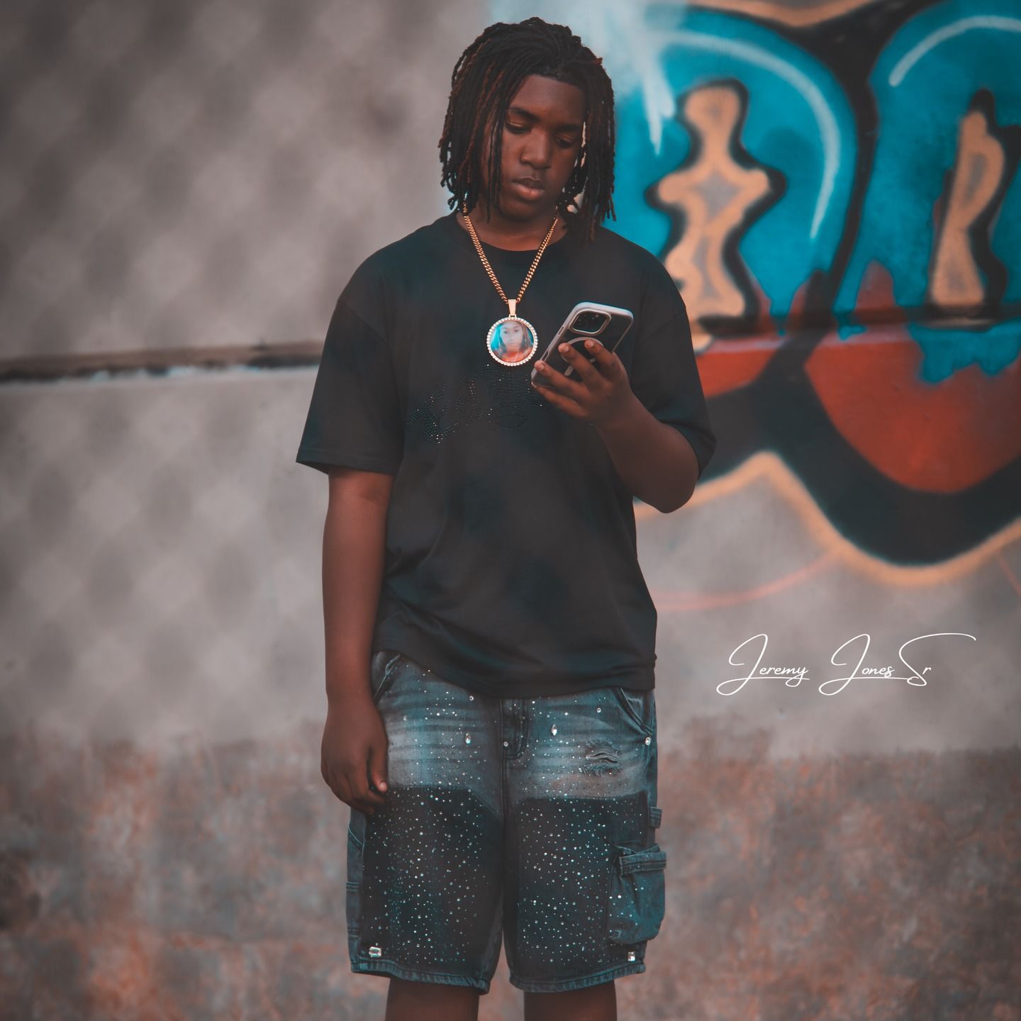 Urban portrait against colorful graffiti wall wearing casual denim shorts.