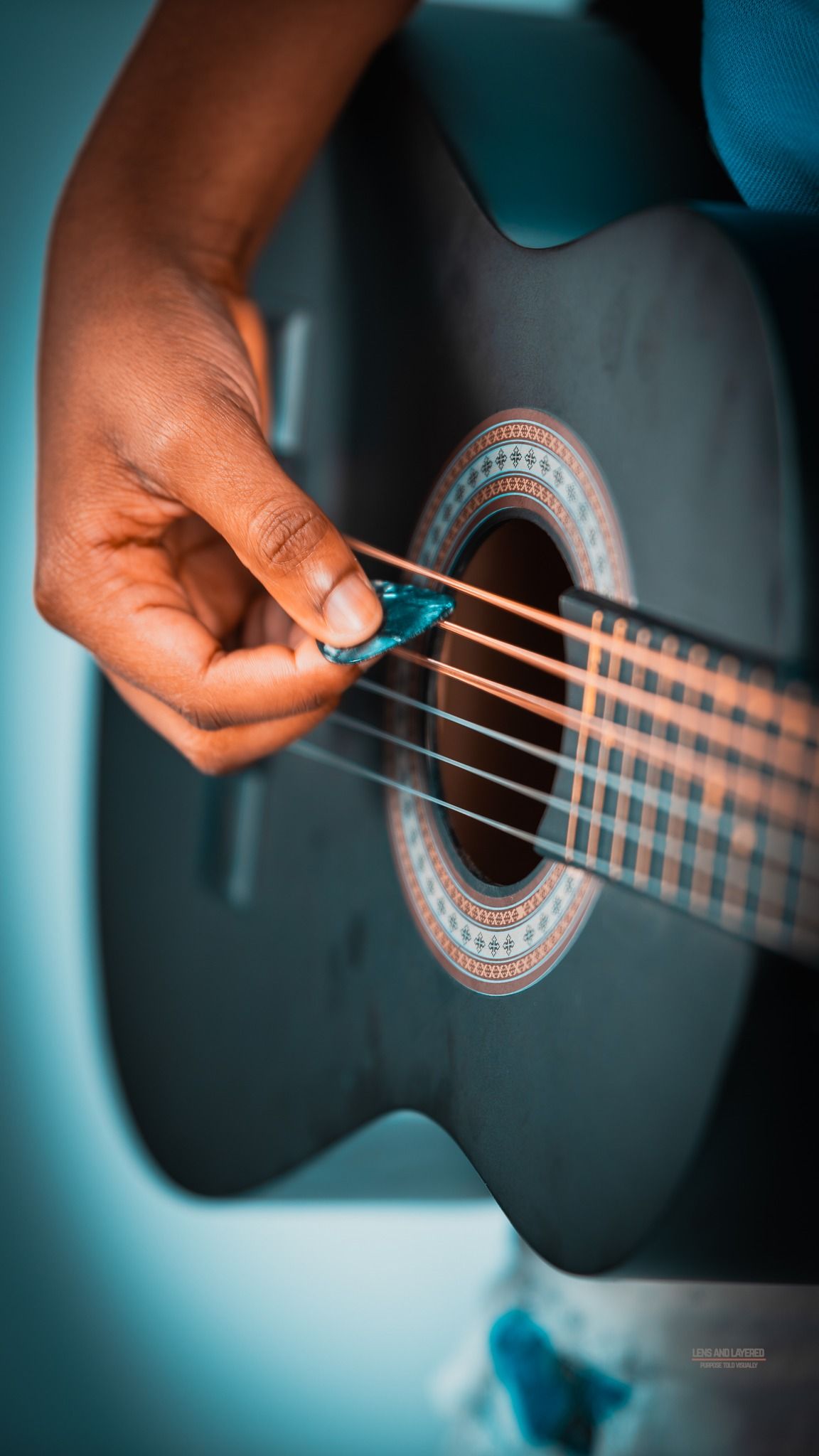 Detailed shots of hands strumming an acoustic guitar with decorative rosette pattern.