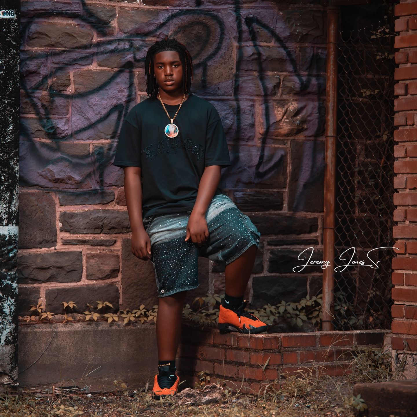 Street style portrait against brick wall with painted graffiti background.