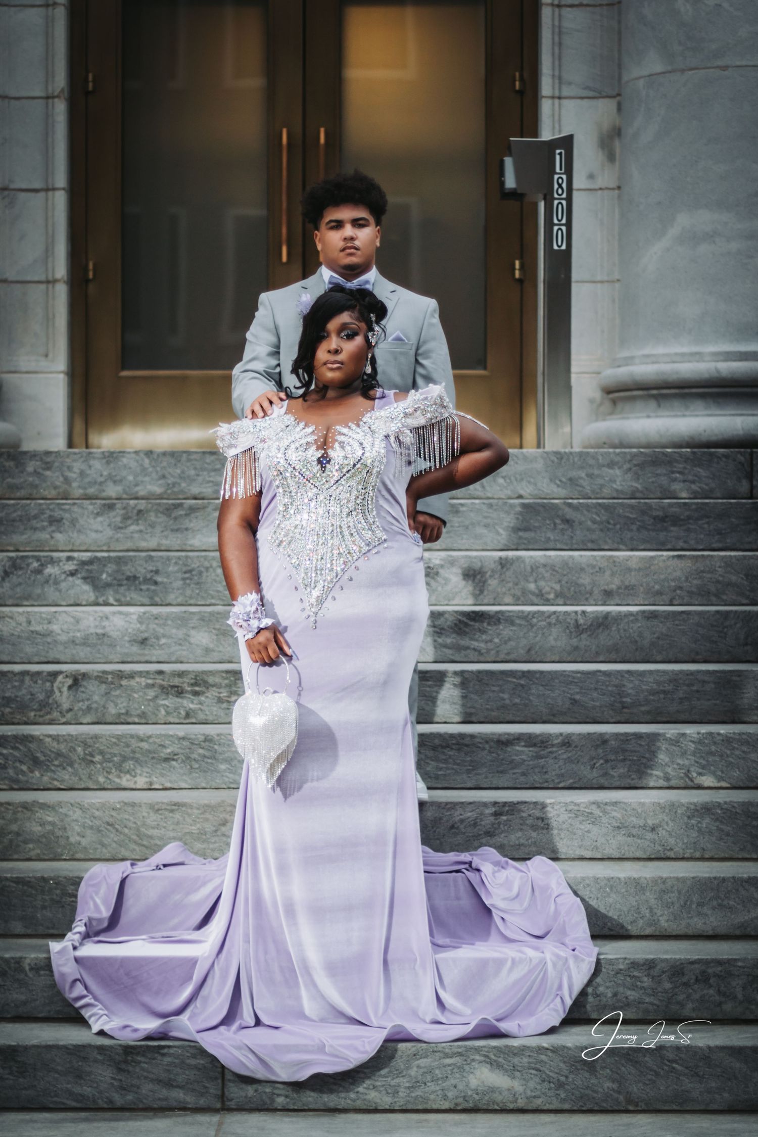 Wedding photo showing a lavender mermaid gown on marble steps.