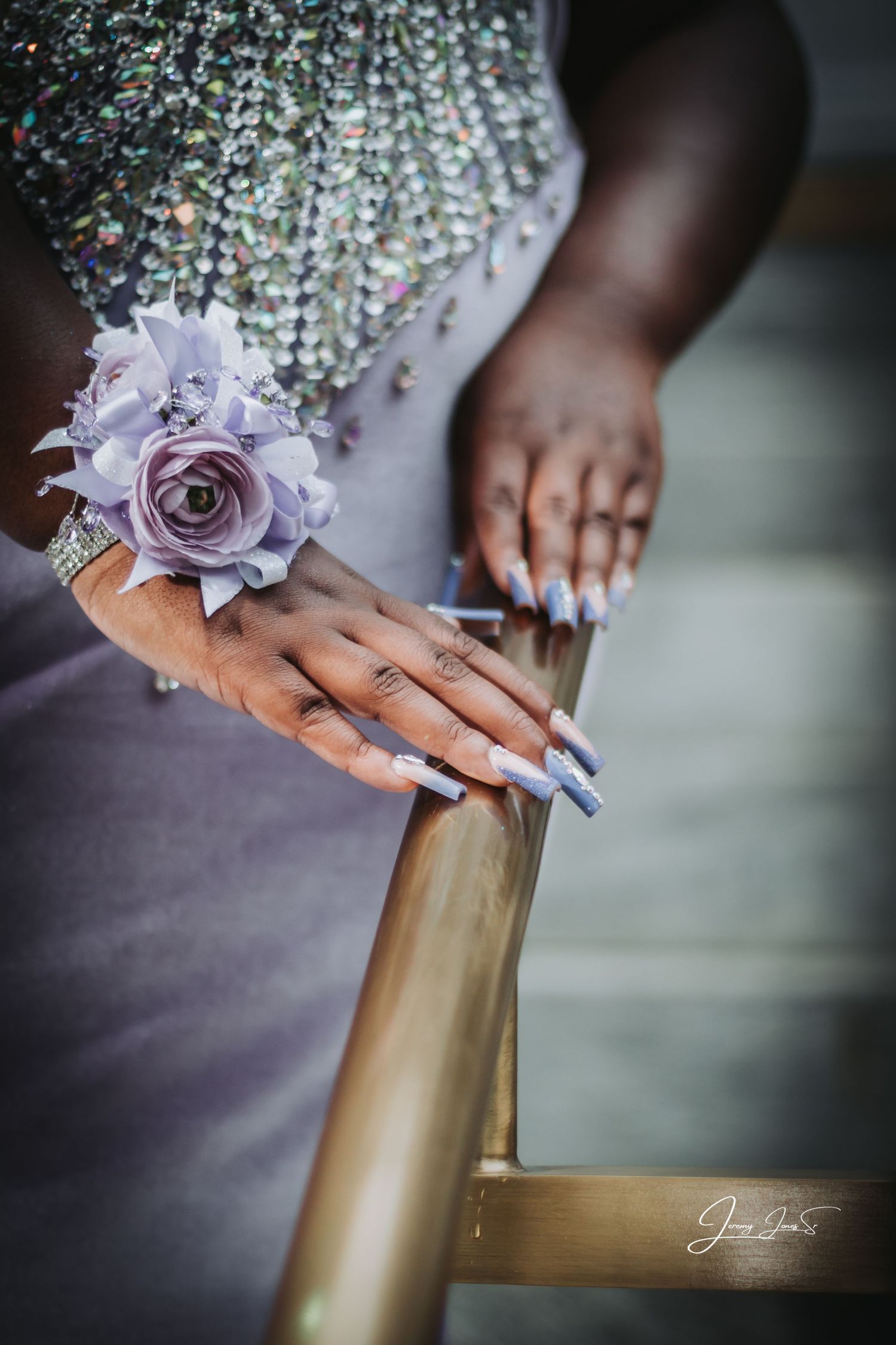 Detailed shot of hands with purple floral decorations and manicured nails.