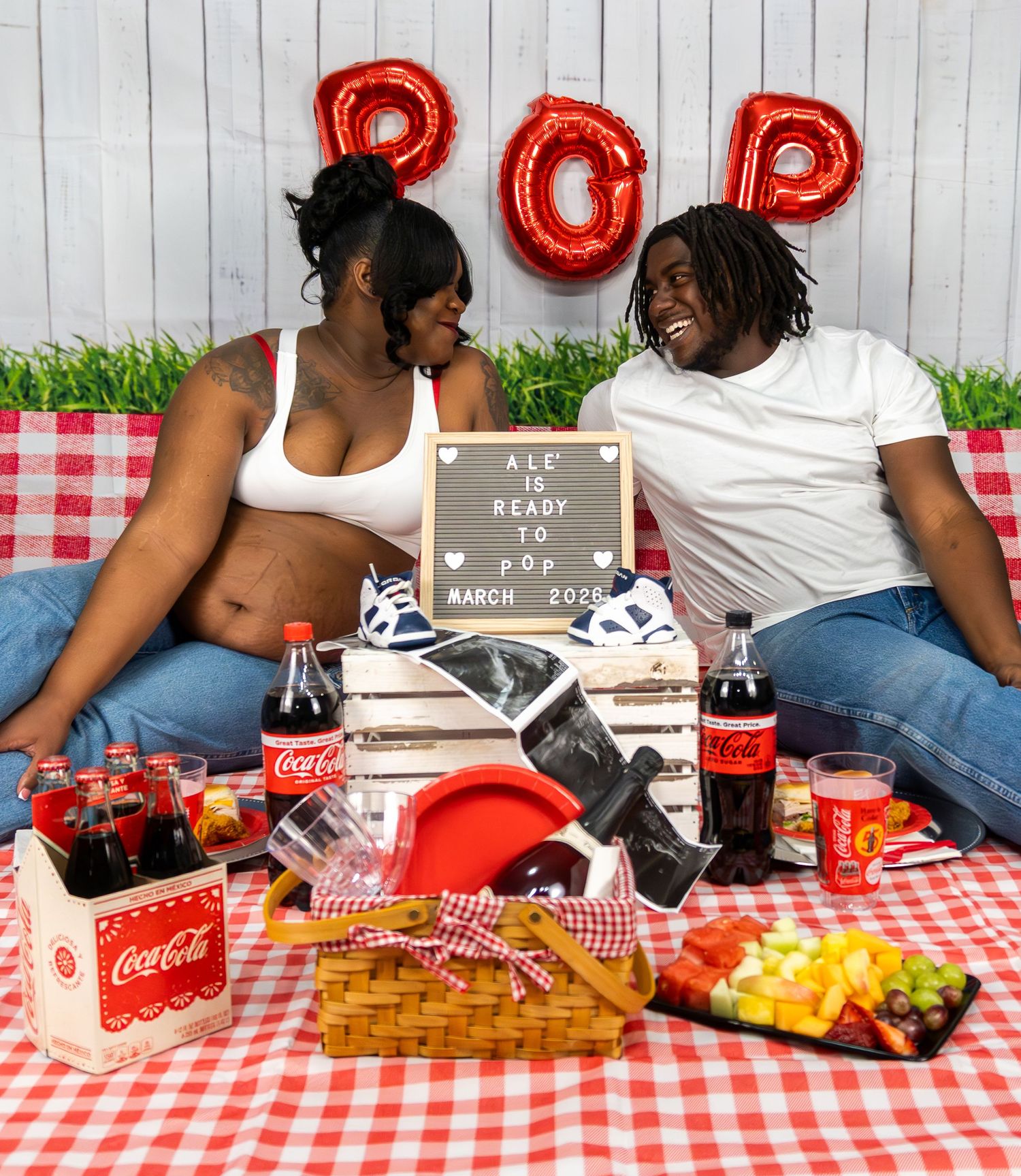 Picnic scene with red checkered tablecloth, Coca-Cola bottles, and snacks.
