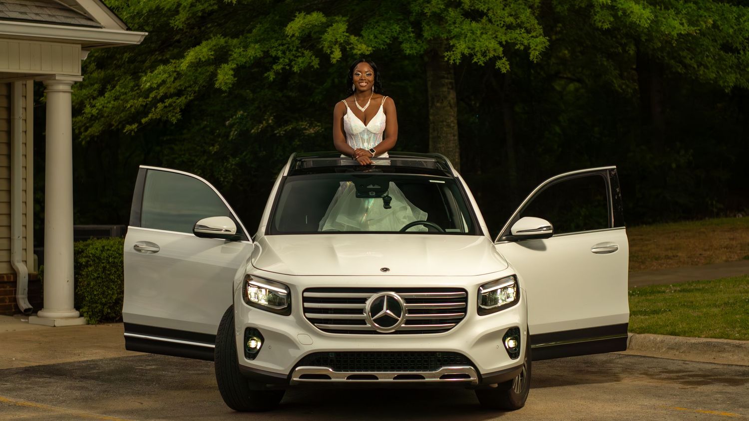 Luxury cars with open doors parked in front of elegant building during special event.