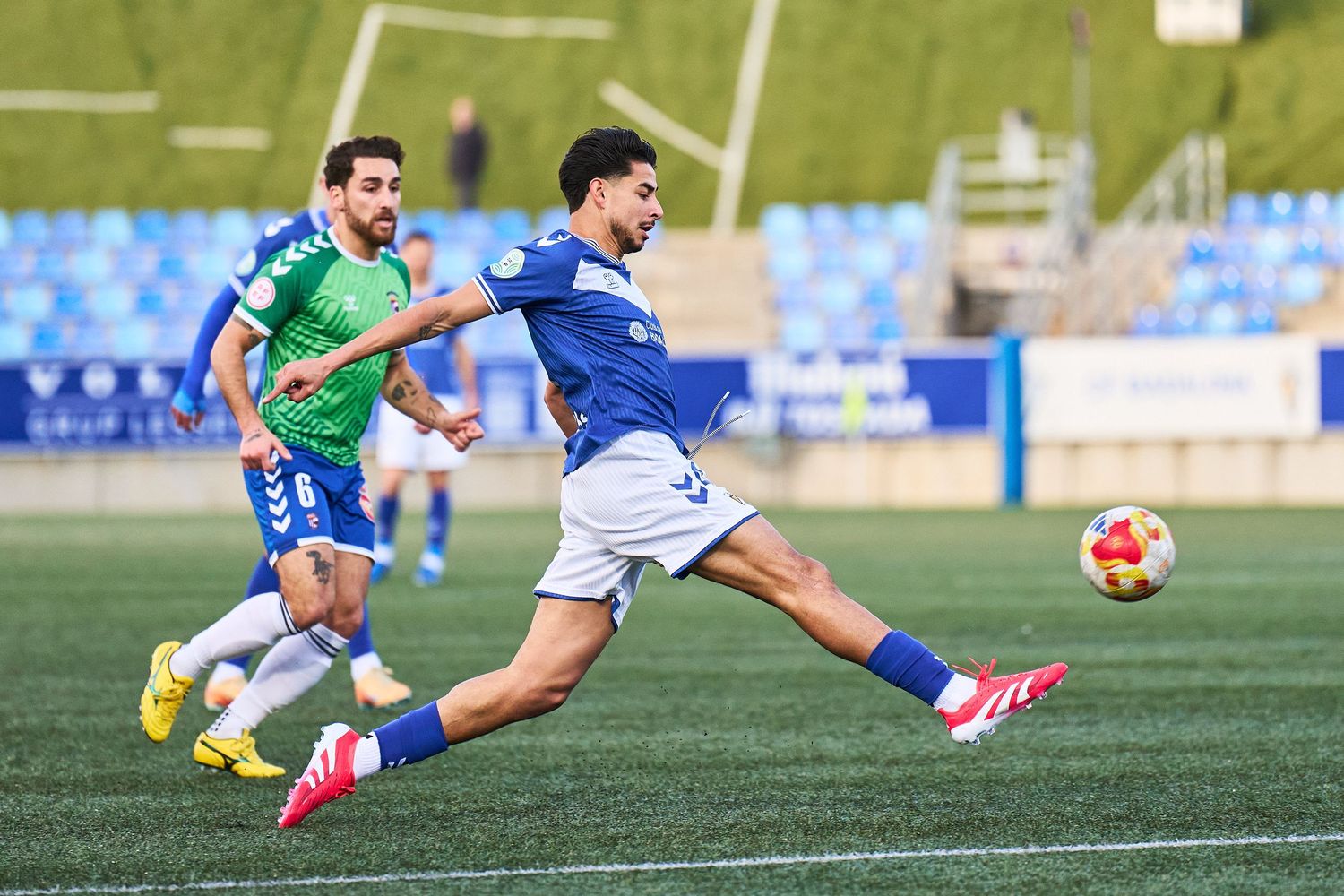 Fotografia esportiva de futbol a Barcelona amb jugador xutant a porteria en ple partit
