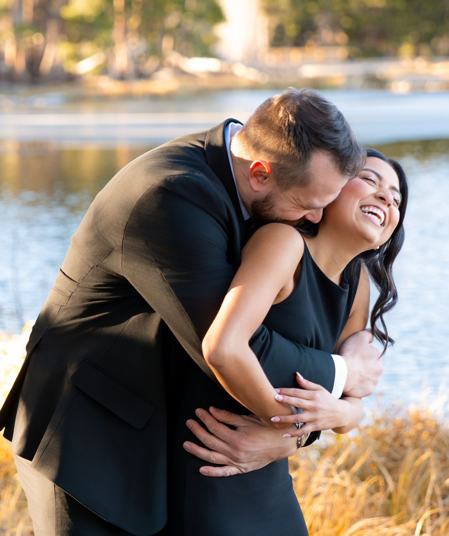 Joyful couple laughing during an engagement photography session at Sprague Lake in Estes Park Colorado.