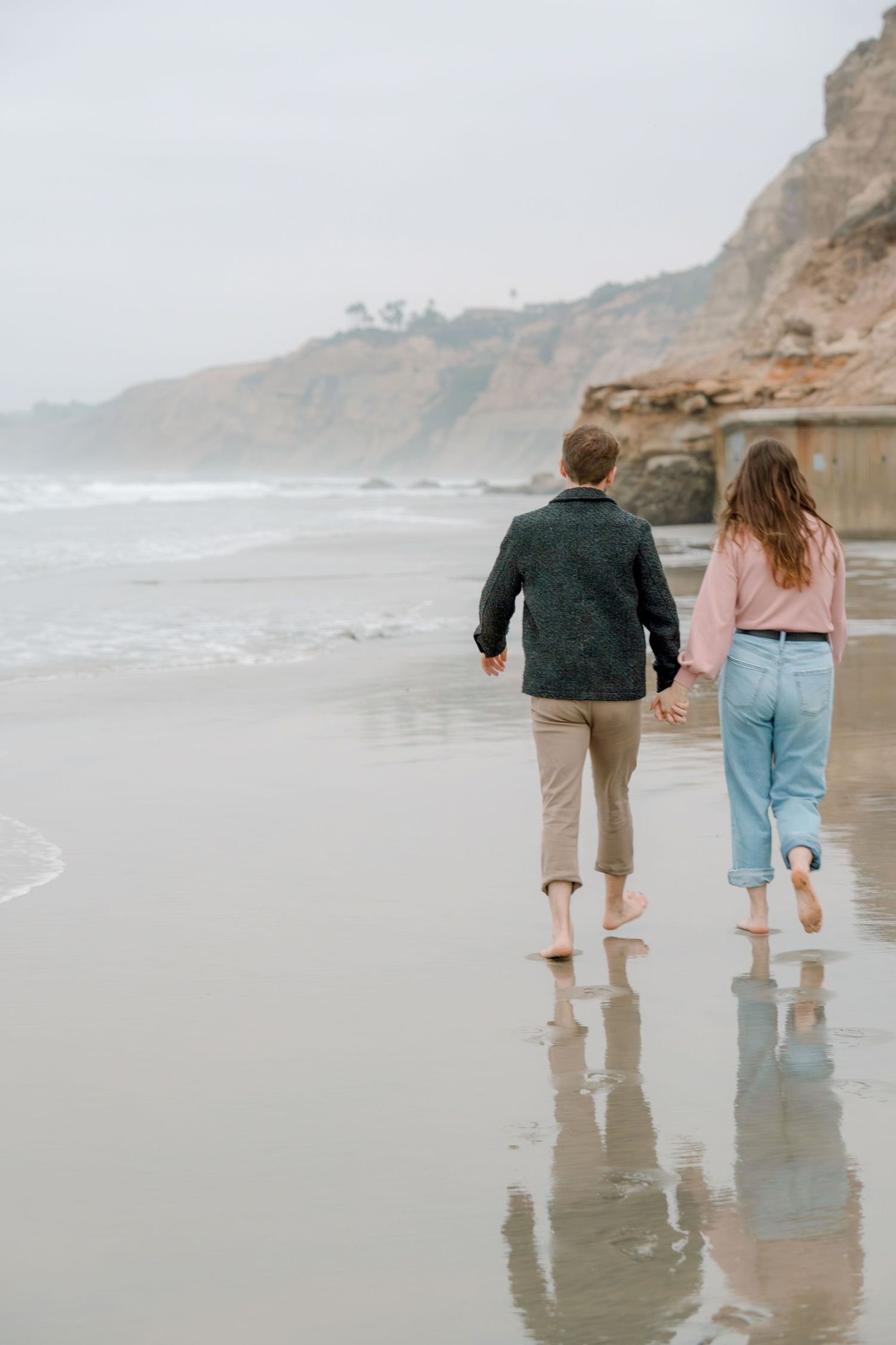 Couple walking along the shoreline during a relaxed outdoor couples photography session captured by a Colorado engagement photographer.